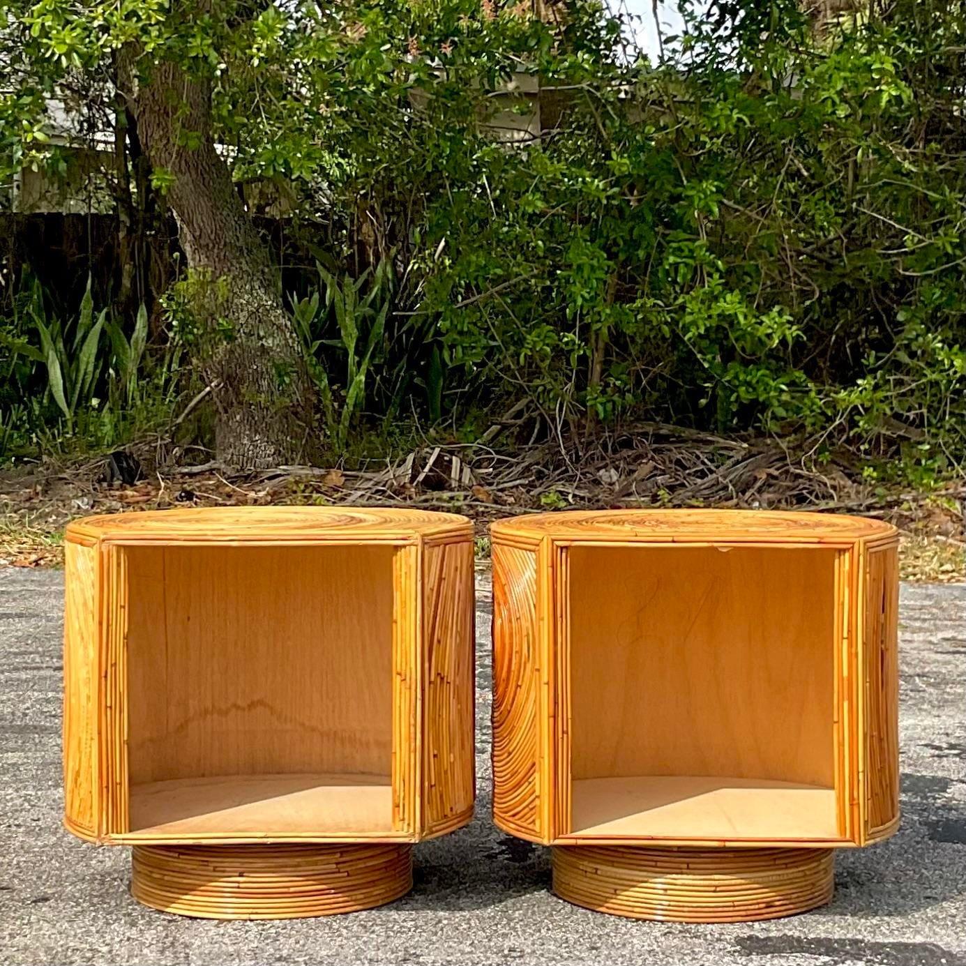 An epic pair of vintage Coastal nightstands. A chic pencil reed cabinet on a swivel base. Look great with the open side forward or closed. You decide! Acquired from a Palm Beach estate.
