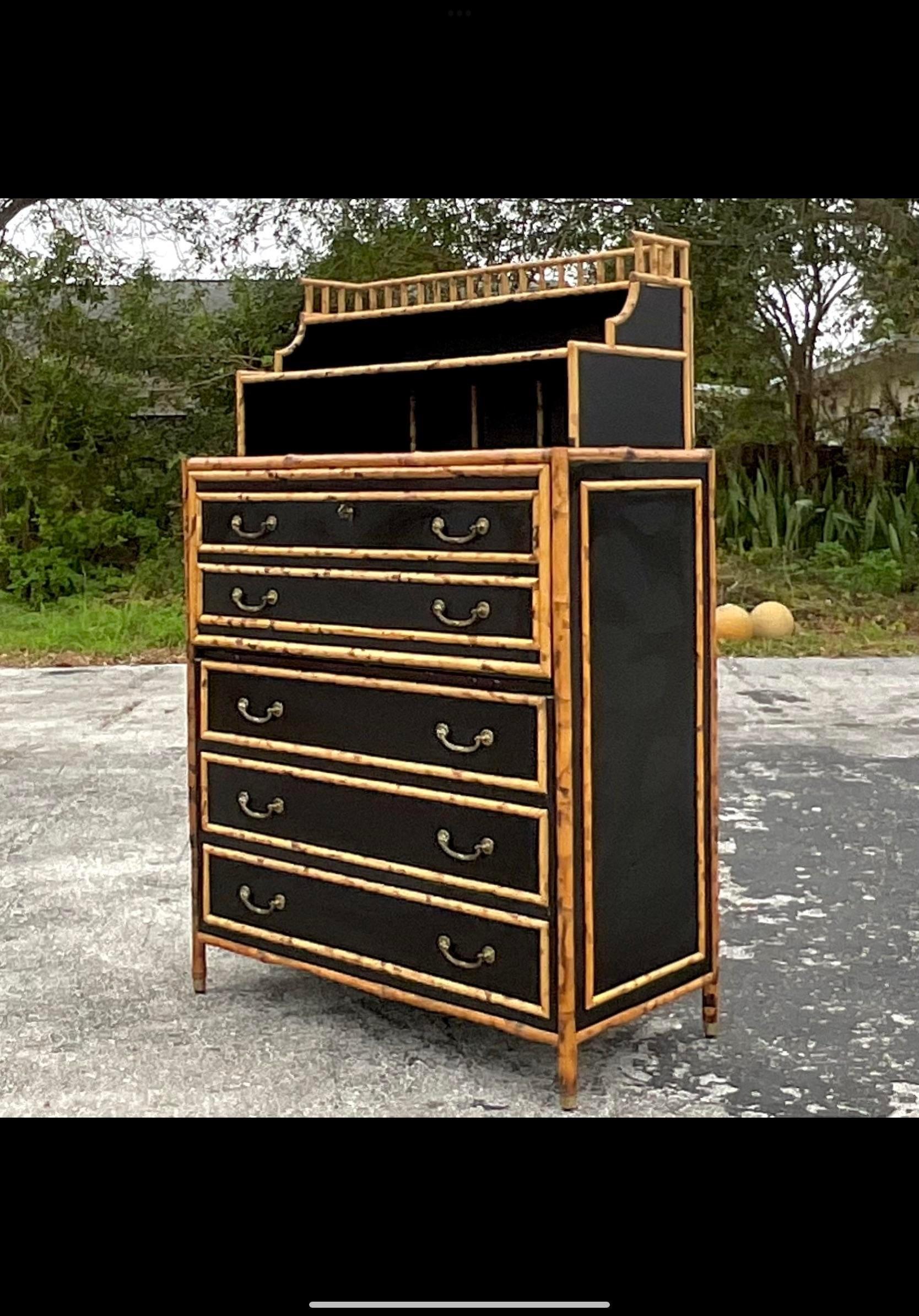 A fantastic vintage Coastal Secretary desk. A chic tortoise shell rattan bamboo with inset black laminate panels. Burnished brass hardware. Flip down desk top with a wrapped leather top. Acquired from a Palm Beach estate.