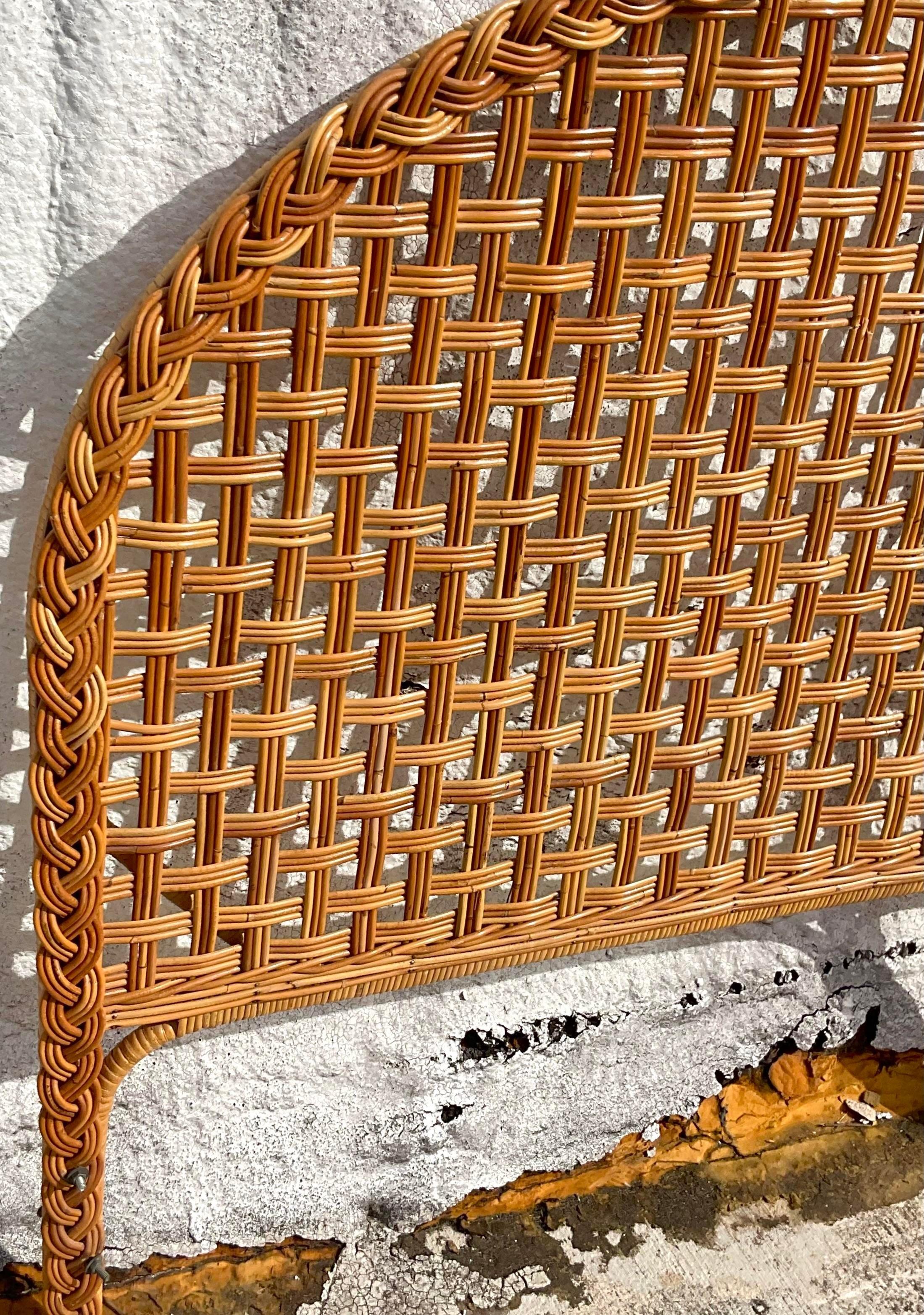Vintage Coastal King Size headboard. A chic arched shape in a open weave rattan and braided trim. Acquired from a Palm Beach estate.