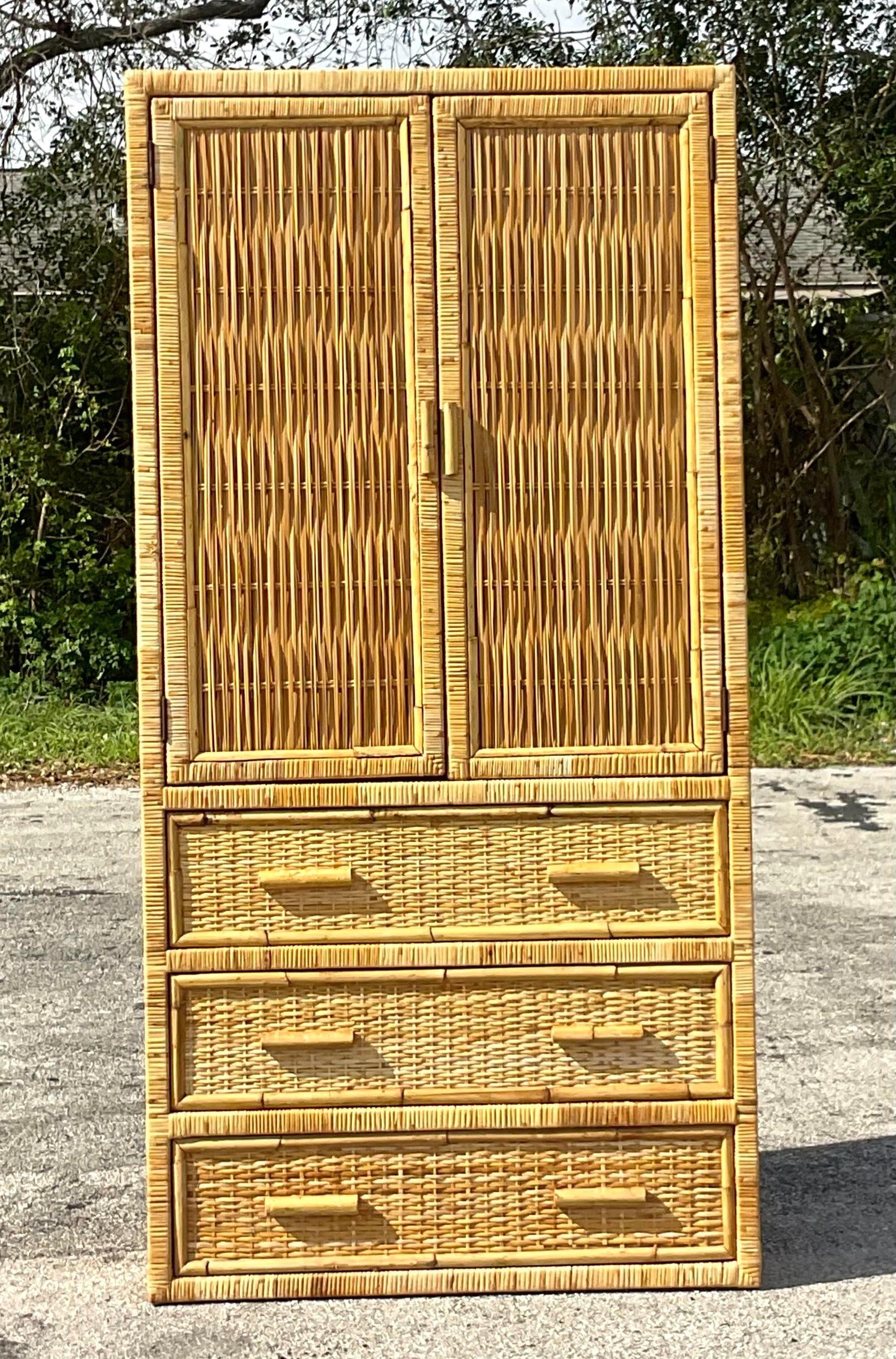A fabulous vintage Coastal armoire. A chic woven rattan with wrapped rattan frame. Lots of great interior shelving makes it perfect for storage. Great in the bathroom, toy room or filled with fluffy white towels in the pool house. Acquired from a