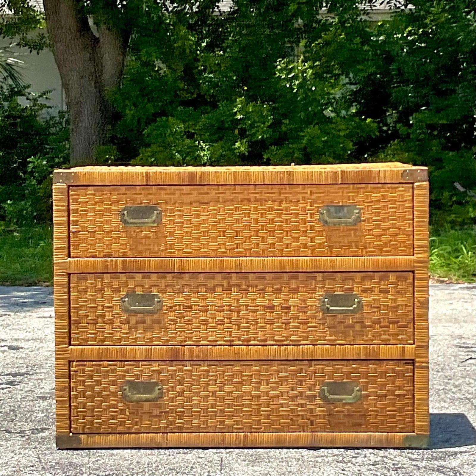 A fabulous vintage Coastal chest of drawers. A chic woven rattan with classic Campaign hardware. Matching nightstands also available.