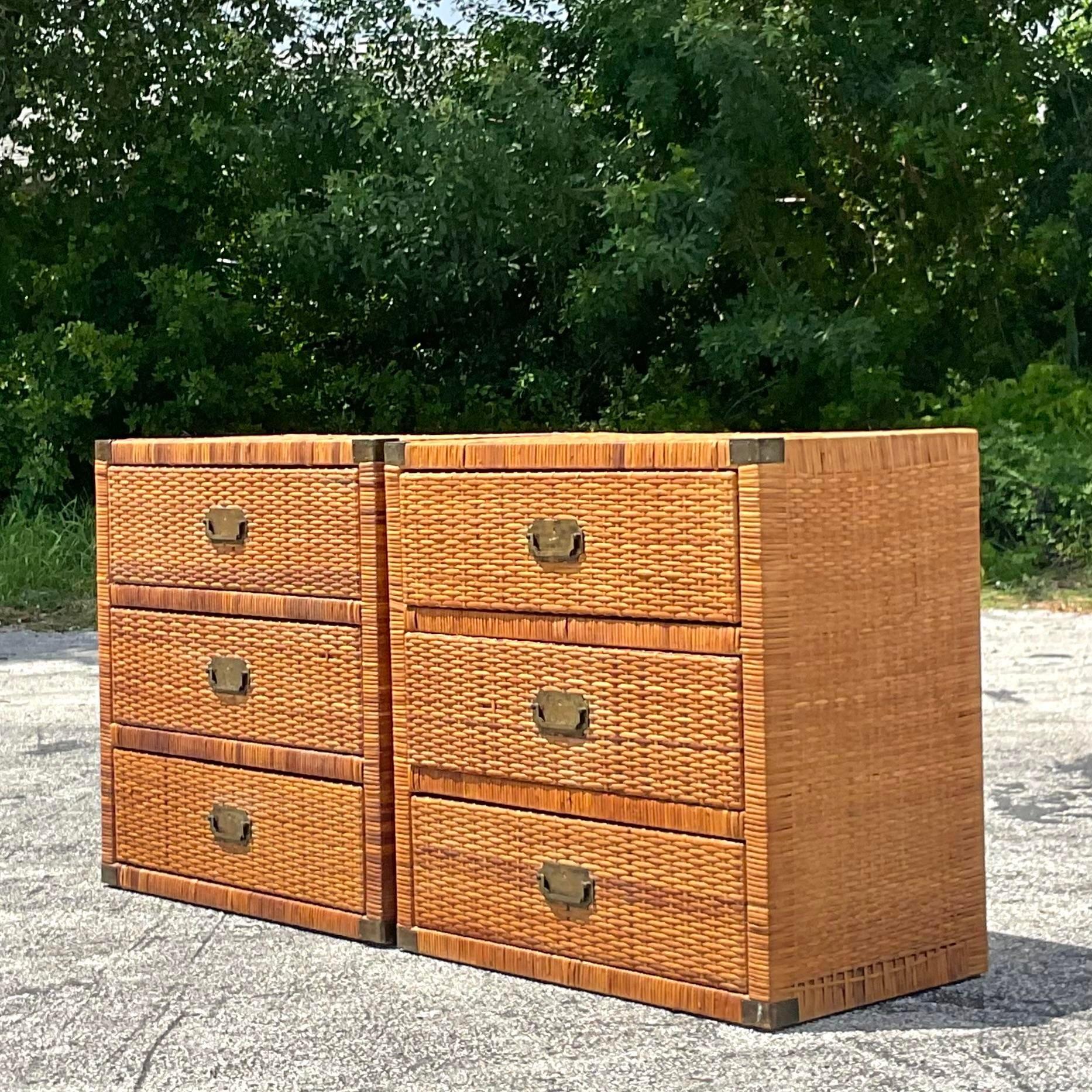A fabulous pair of vintage Coastal chest of drawers. A chic woven rattan with brass campaign hardware. Perfect as chests, nightstands or push together for a dresser. You decide! Acquired from a Palm Beach estate.
