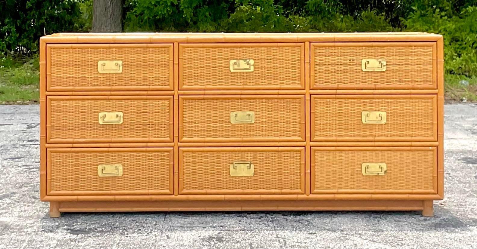 A fabulous vintage Coastal standard dresser. Beautiful woven rattan frame with rattan trim. Beautiful Campaign drawer pulls. Acquired from a Palm Beach estate.