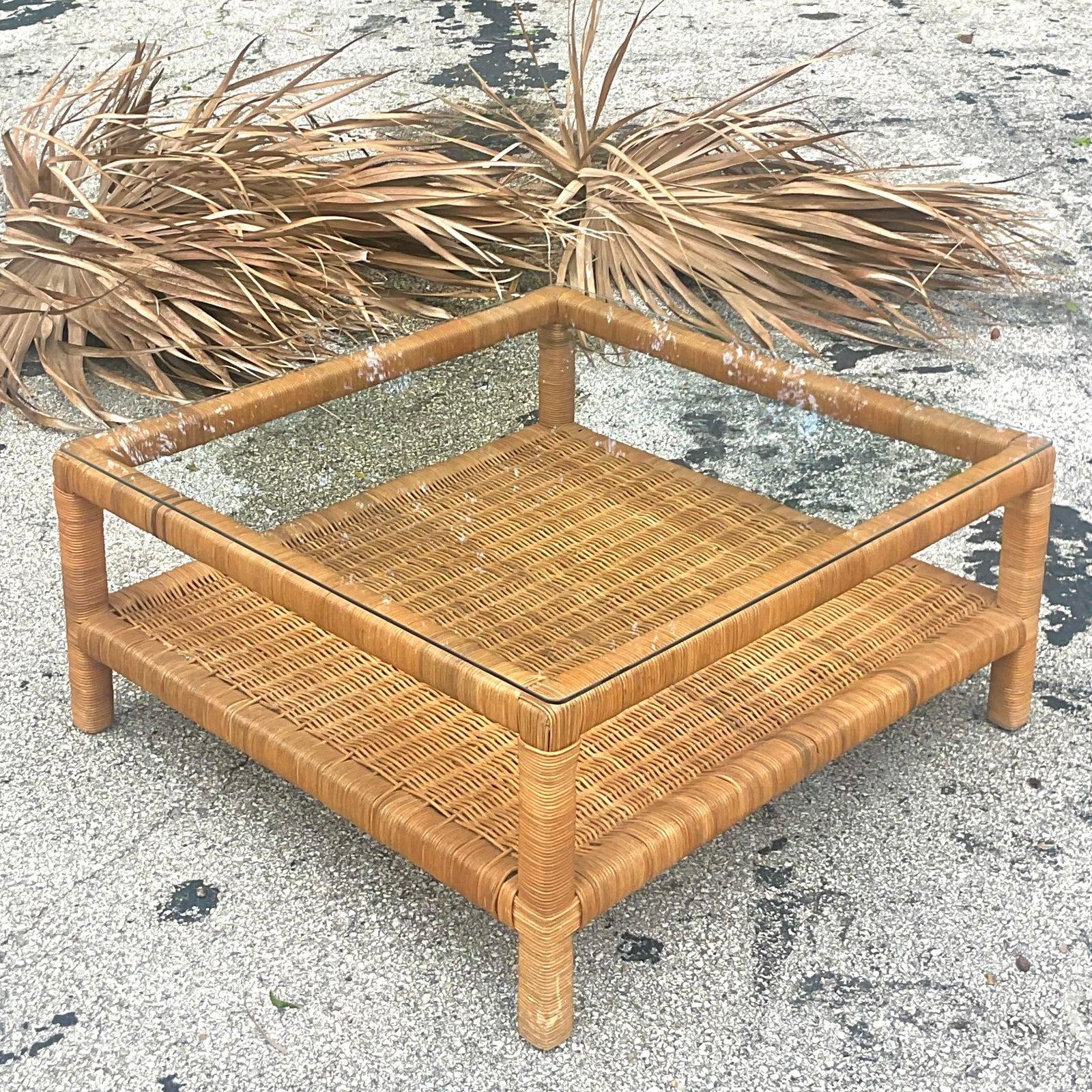 Une fabuleuse table basse côtière vintage. Un cadre chic en rotin tressé avec un plateau en verre. Simple et élégant. Une étagère inférieure pour exposer vos collections préférées. Acquis d'une propriété de Palm Beach.