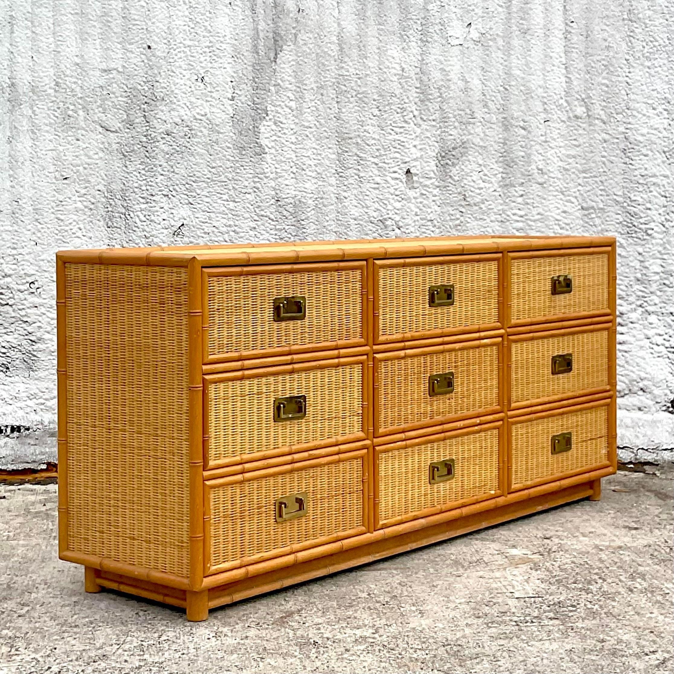 A fabulous vintage Coastal 9 drawer dresser. Chic woven rattan panels with a carved bamboo trim. Gorgeous brass campaign hardware. Acquired from a Palm Beach estate.