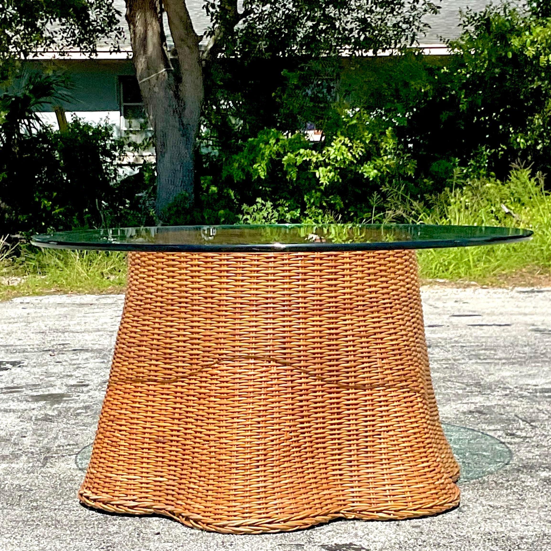 A stunning vintage Coastal center hall table. A chic woven rattan in the coveted ghost shape. A charming little Ruffle along the bottom edge. Acquired from a Palm Beach estate.