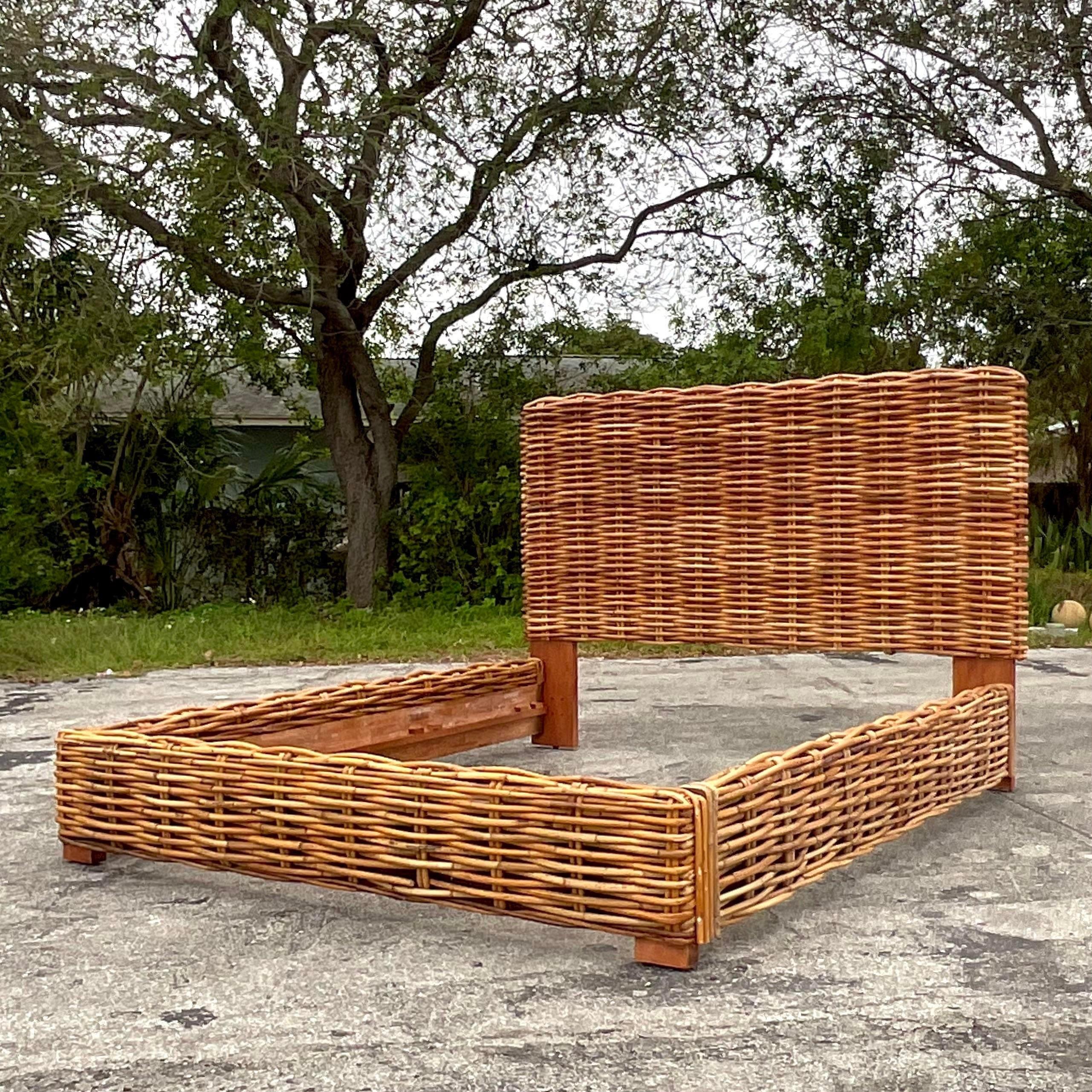 A fabulous vintage Coastal King bed frame. A chic woven rattan construction. A high back and rattan covered bed rails. Acquired from a Palm Beach estate.
