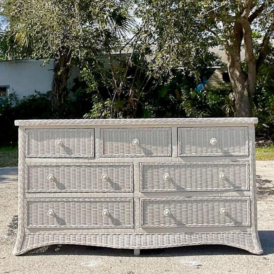 A gorgeous coastal 7 drawer dresser. A chic roll from shape in a woven rattan cabinet. Sure to add a flash of charm to any space. Acquired from a Palm Beach estate. 