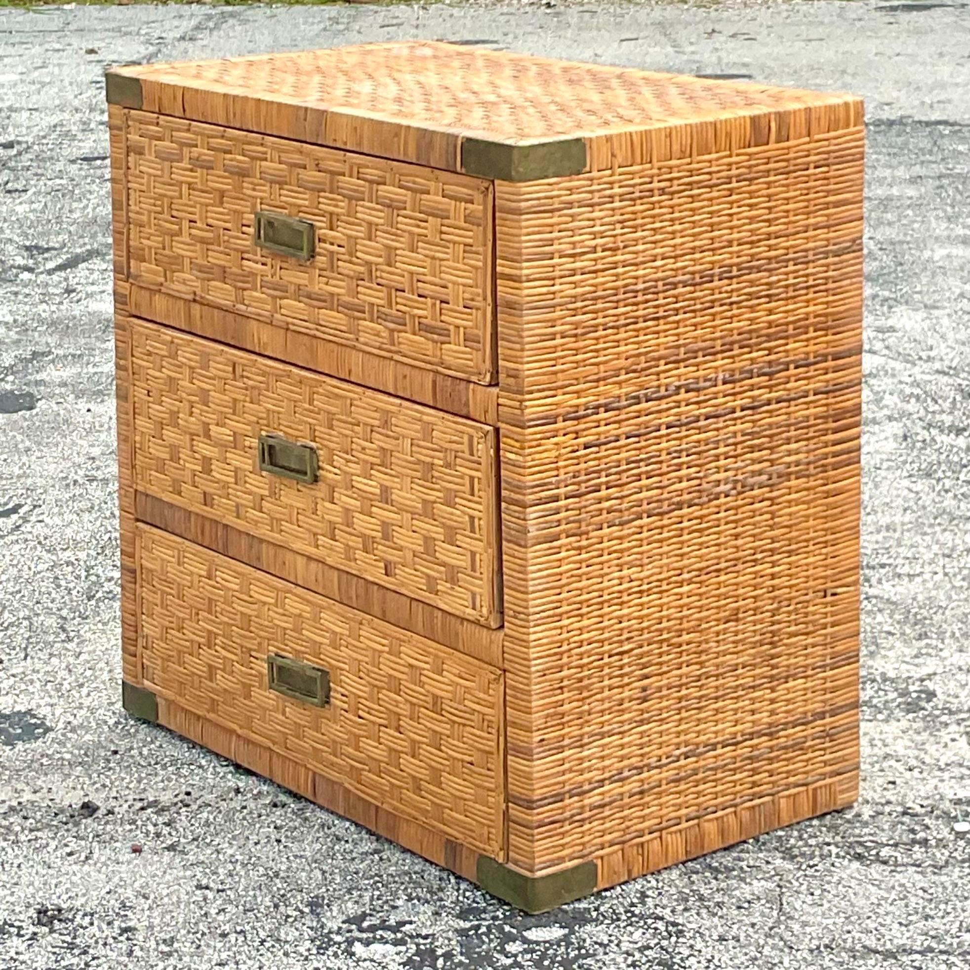 Vintage Coastal chest of drawers. A chic wrapped rattan frame with inset woven rattan panels. Brass campaign hardware. Acquired from a Palm Beach estate. 