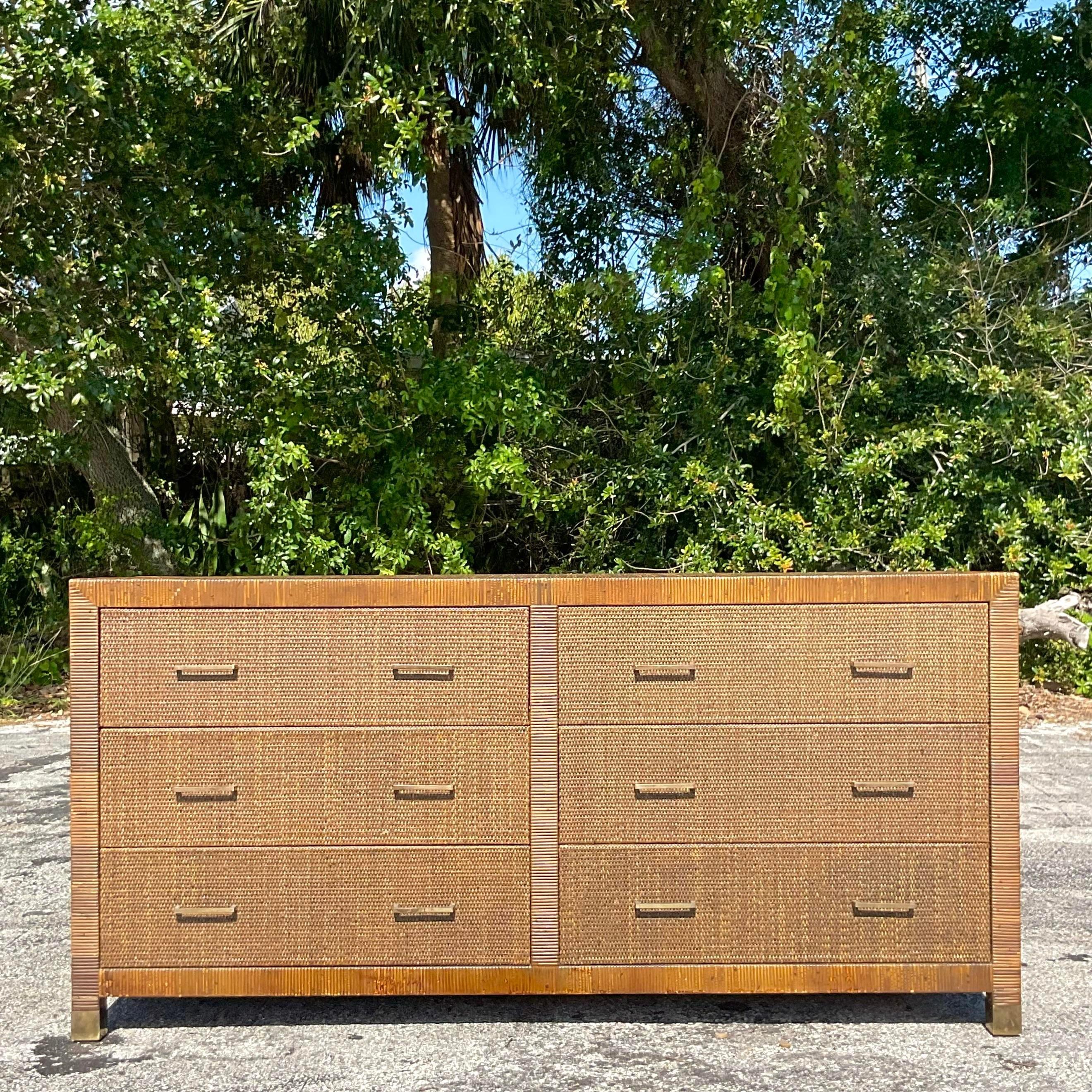 Elevate your coastal retreat with this Vintage Wrapped Rattan Dresser, a nod to classic American craftsmanship. Its charming design, featuring wrapped rattan detailing, brings a touch of seaside allure to any space, offering both storage and style
