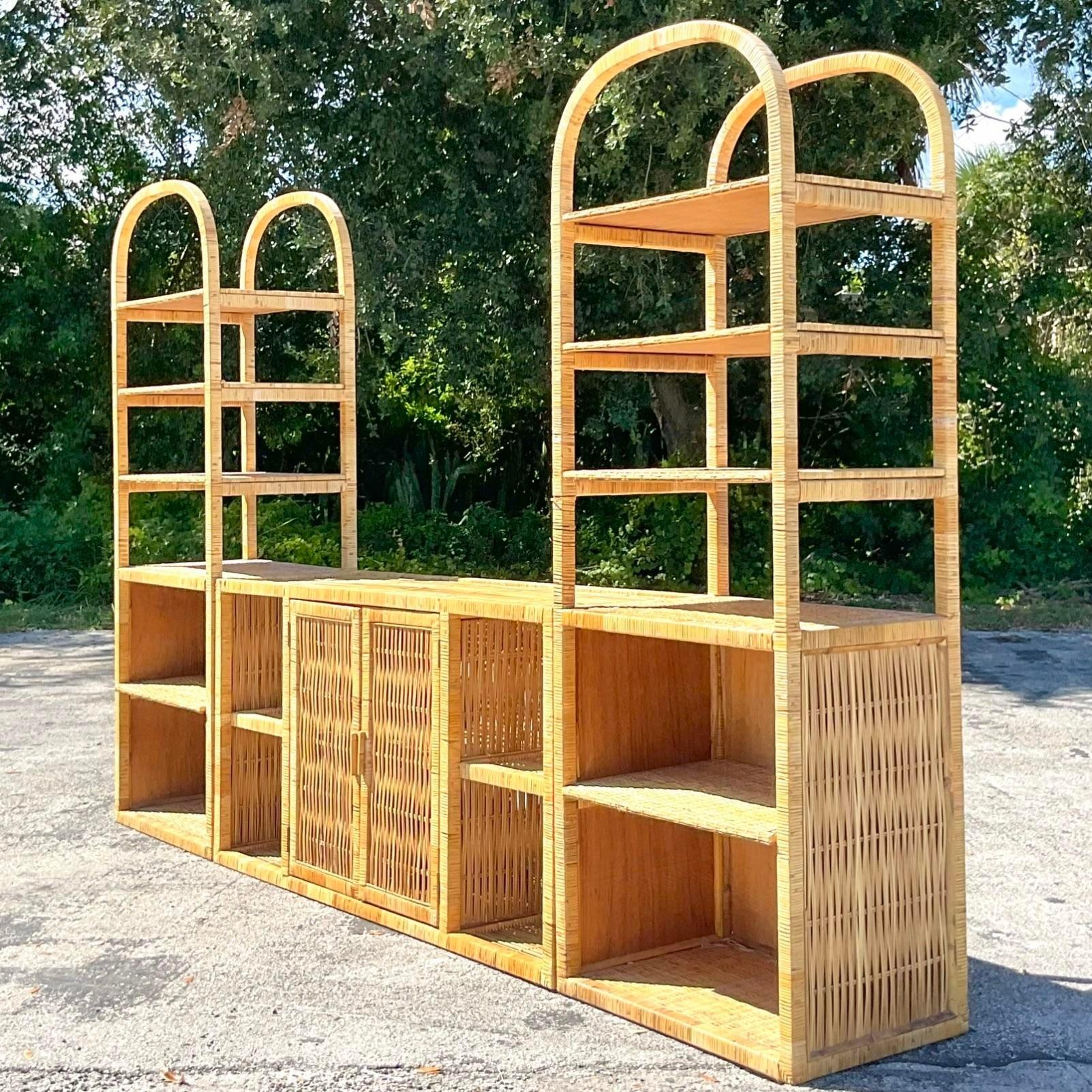 A fabulous pair of vintage Costal etagere. A chic arched design with a wrapped rattan frame. Deep set shelving with lots of great storage below. Can be added to the ends of a coordinating credenza for a killer wall unit. The credenza is also