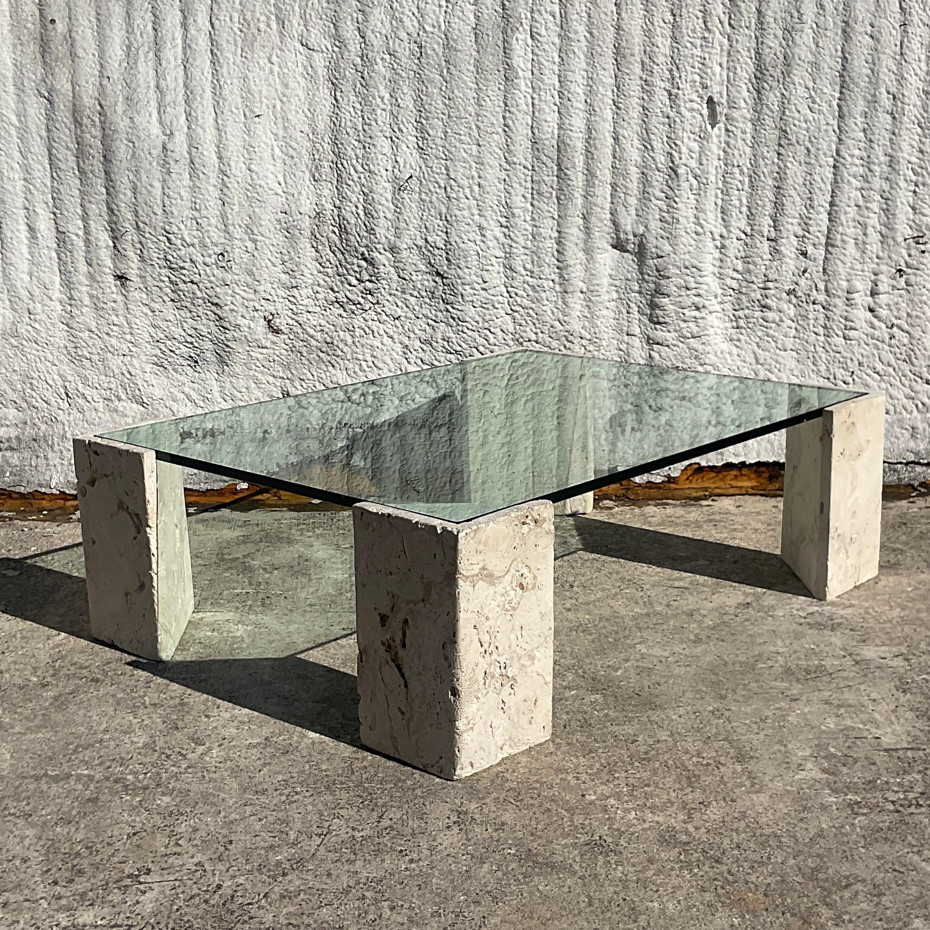 A fantastic vintage Coastal coffee table. A chic design of four coquina stone pedestal with an inset glass top. Perfect indoors or outside. Acquired from a Palm Beach estate