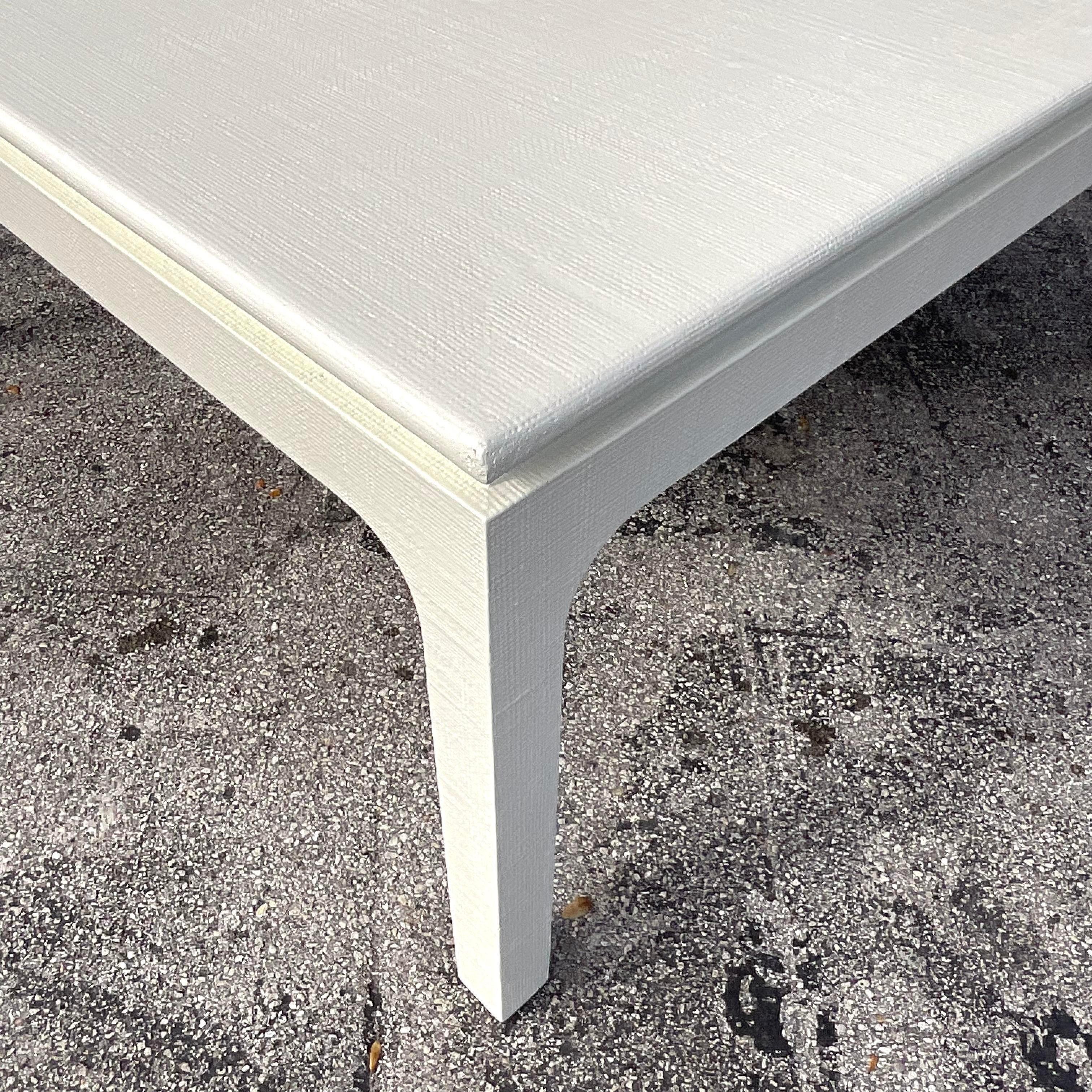 A stunning vintage Coastal dining table. A chic wrapped Grasscloth in a freshly lacquered off white. A large square profile in a classic parsons shape. Acquired from a Palm Beach estate