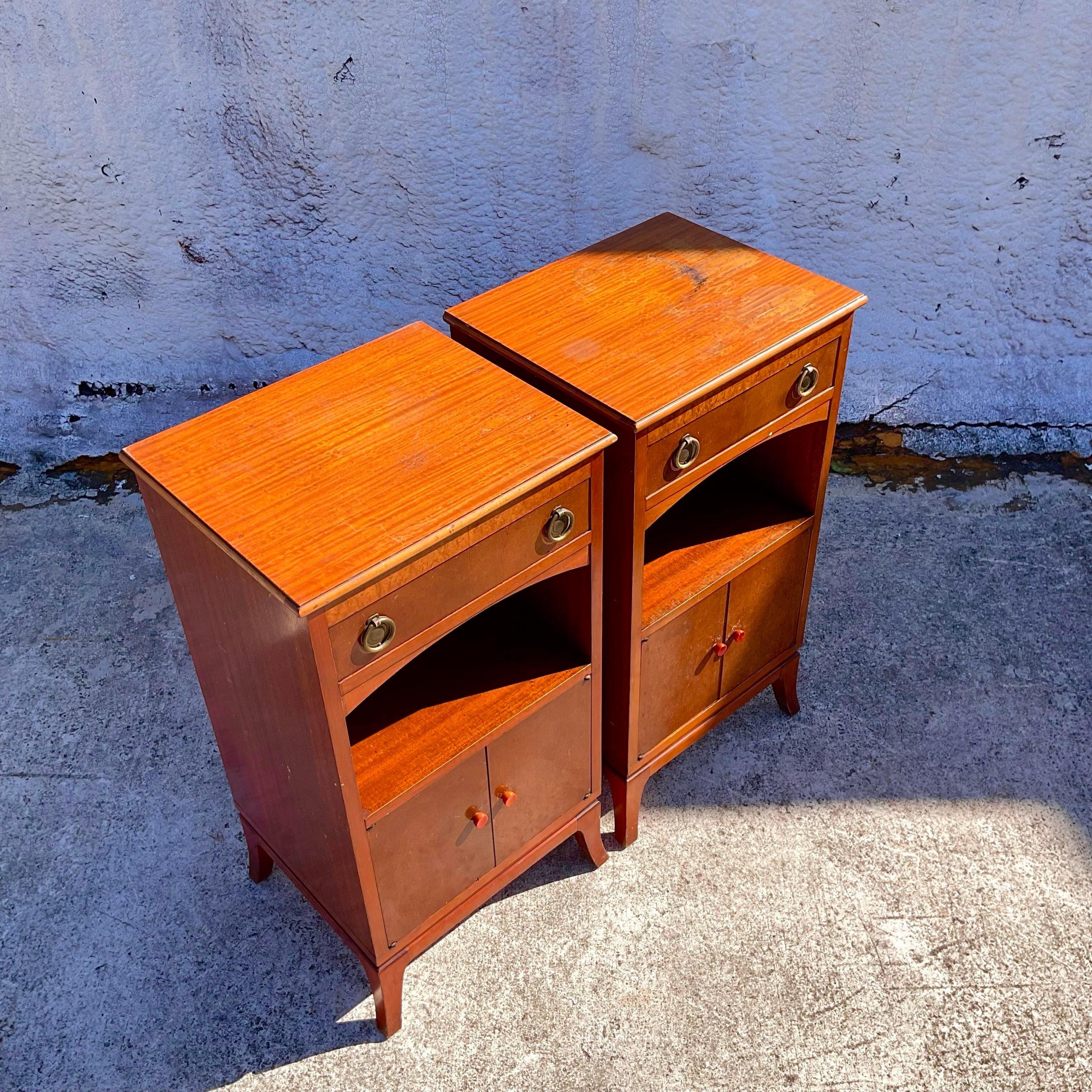 A fantastic pair of vintage John Stewart petite nightstands with a top drawer, a shelf and cabinet doors. The bakelite handles add a touch of distinction. These are beautiful nightstands that need a little TLC and then you will have real gems.