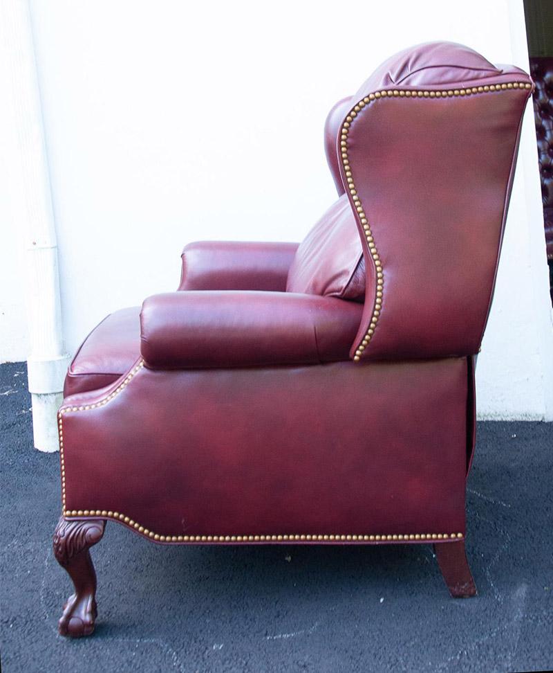 Beautiful vintage leather recliner in a deep rich burgundy. Carved lion claw front legs and accented with antique gold nailheads. Removable seat cushion and fitted back cushions. Easy to operate and very soft leather. When it is in the recline