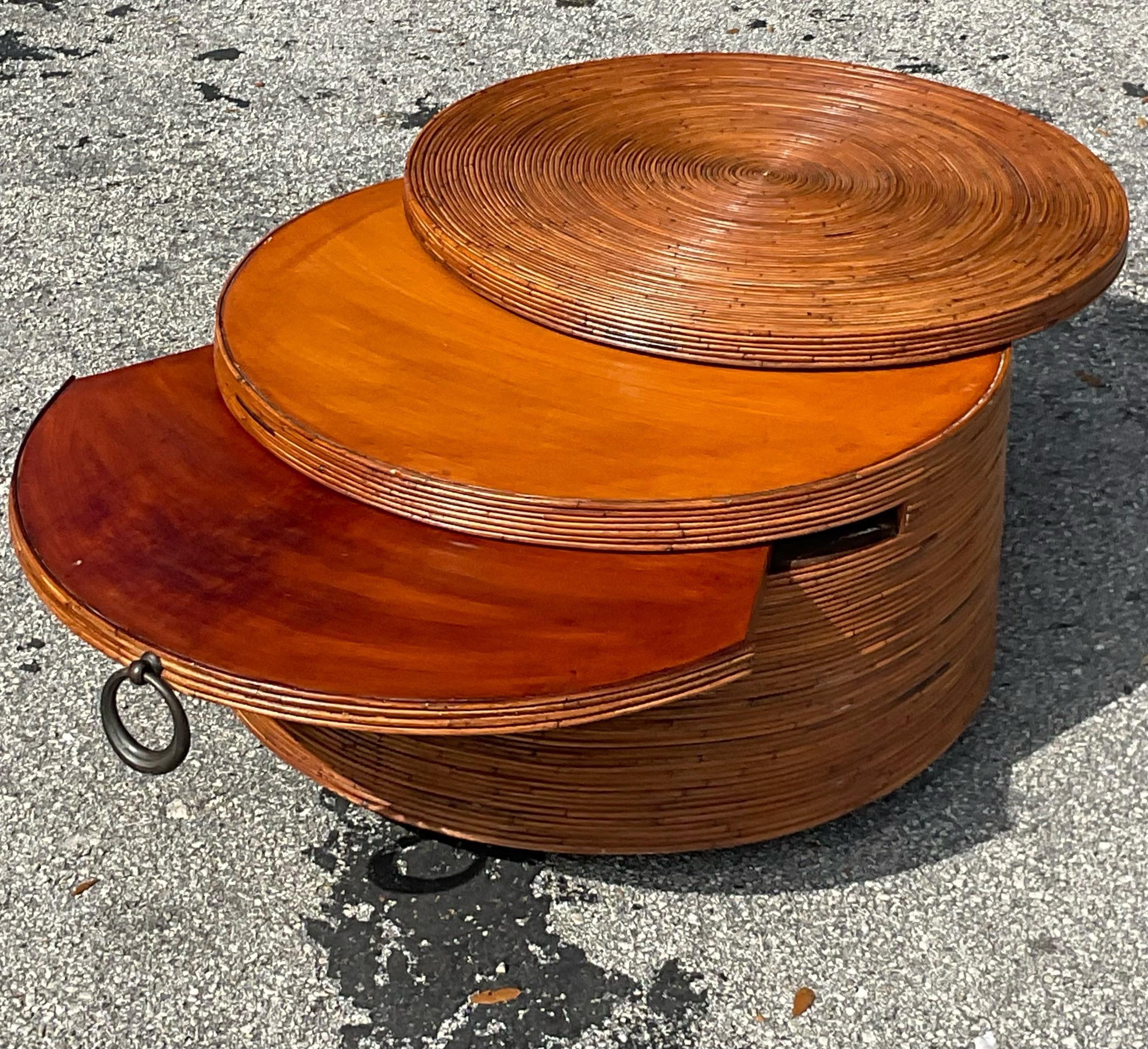 Incredible vintage bamboo pencil reed round coffee cocktail table with a hidden extension and swivel top to expand for extra space. Acquired from a Palm Beach estate.