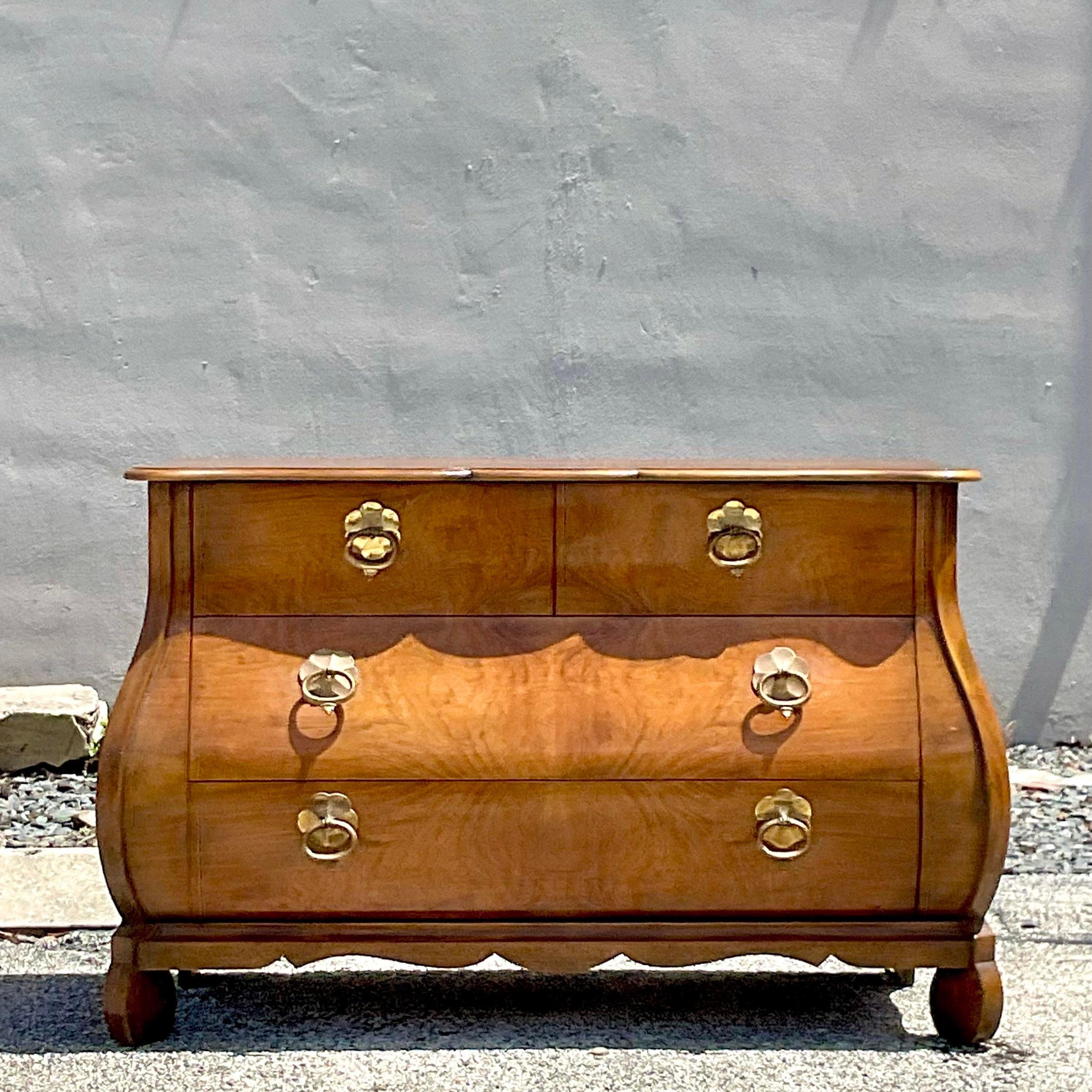 A fabulous vintage Regency chest of drawers. A beautiful Bombe front with a scalloped apron along the bottom. Made by the iconic Baker Furniture group. Marked inside the drawer. Acquired from a Palm Beach estate.