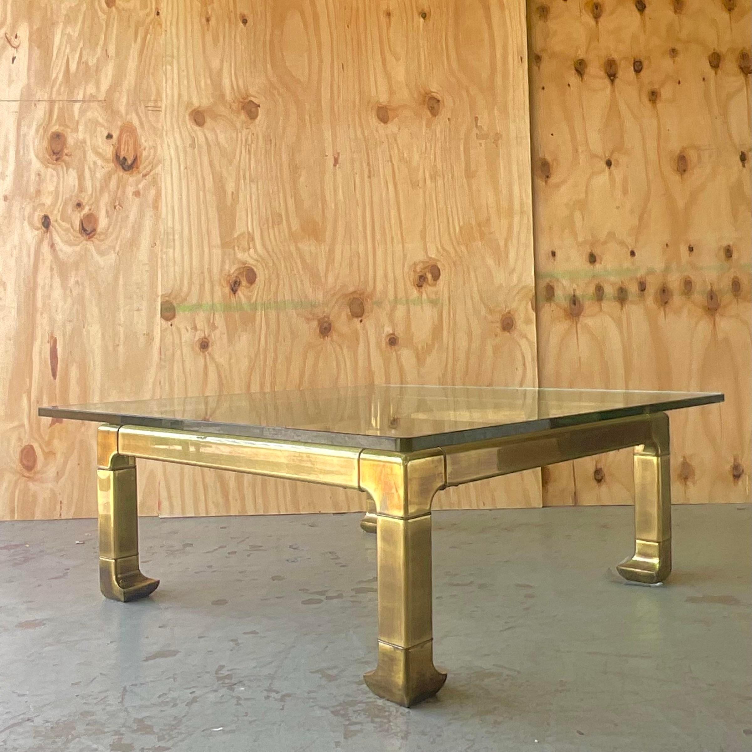 A stunning vintage Regency coffee table. A chic brass frame with thick glass top done in the manner of Mastercraft. Acquired from a Palm Beach estate. 