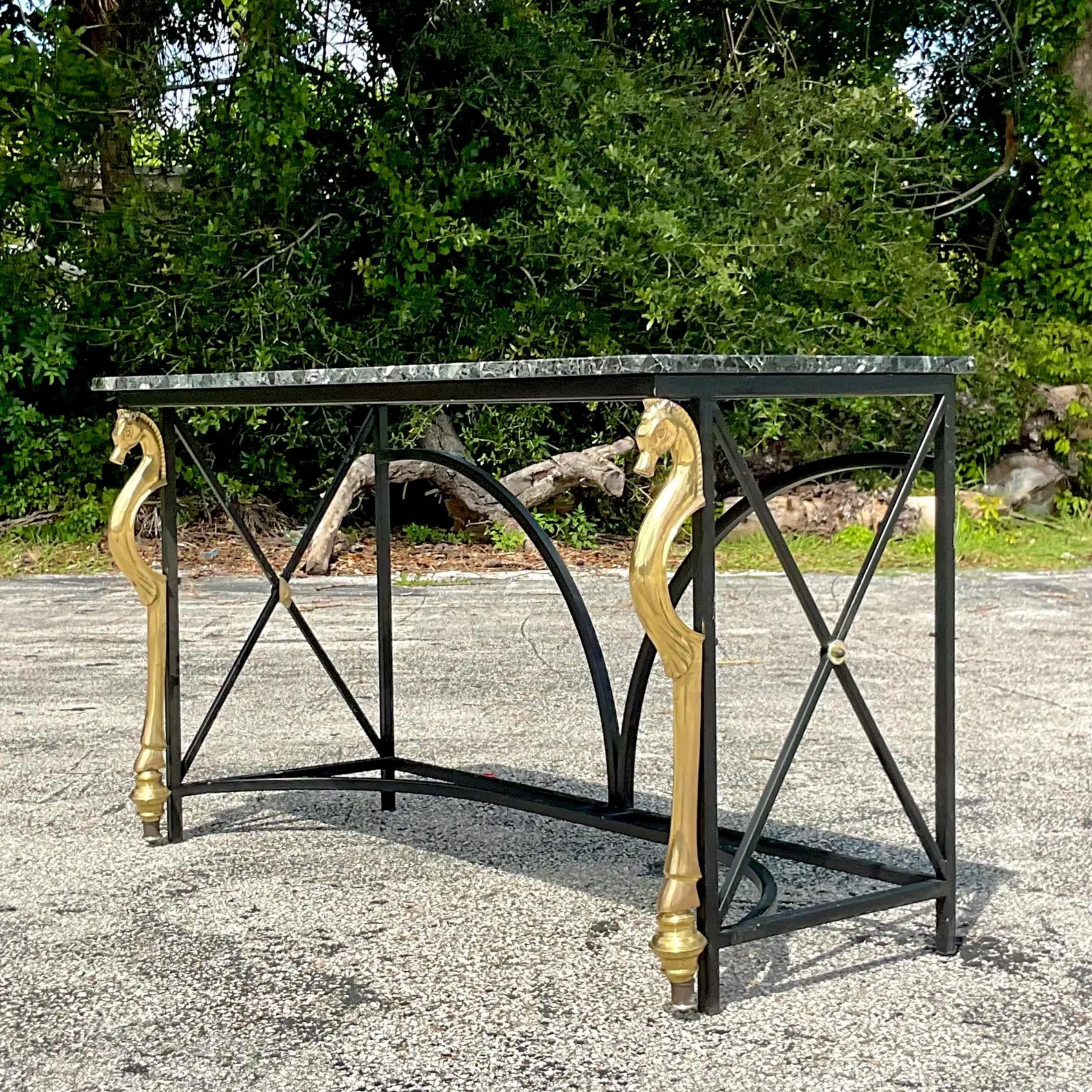 A fantastic vintage Regency console table. A chic tubular frame with a gorgeous pair of brass horse heads. A beautiful black stone top. Acquired from a Palm Beach estate.