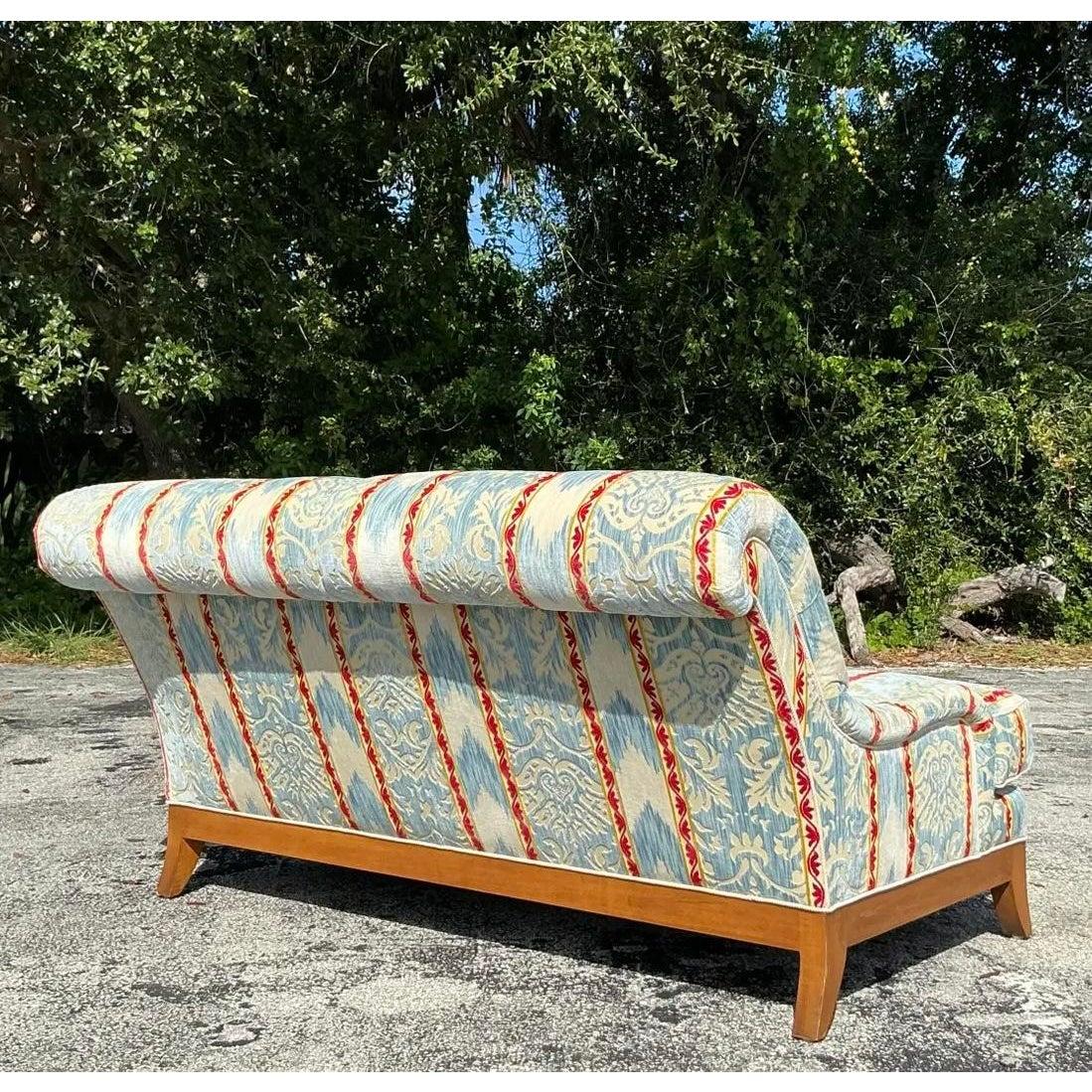 Discover the allure of classic design with this exquisite Vintage Regency loveseat, a piece that effortlessly blends sophisticated style with inviting comfort. This loveseat showcases a gracefully curved back and a refined wood frame, hallmarks of