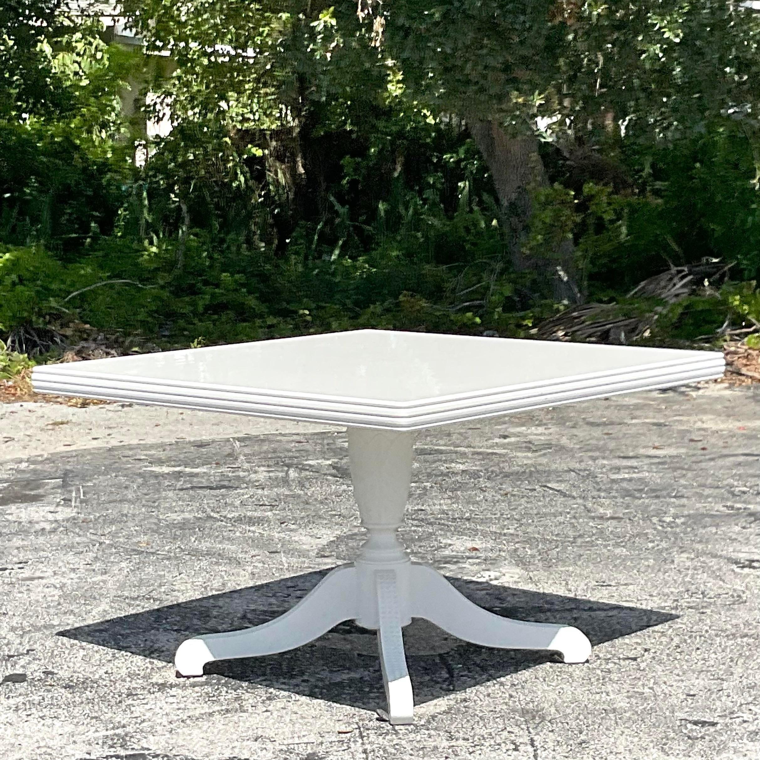A fantastic vintage Regency dining table. A fabulous Duncan Phyfe design in a white lacquered finish. Hand carved detail on the legs. Acquired from a Palm Beach estate.