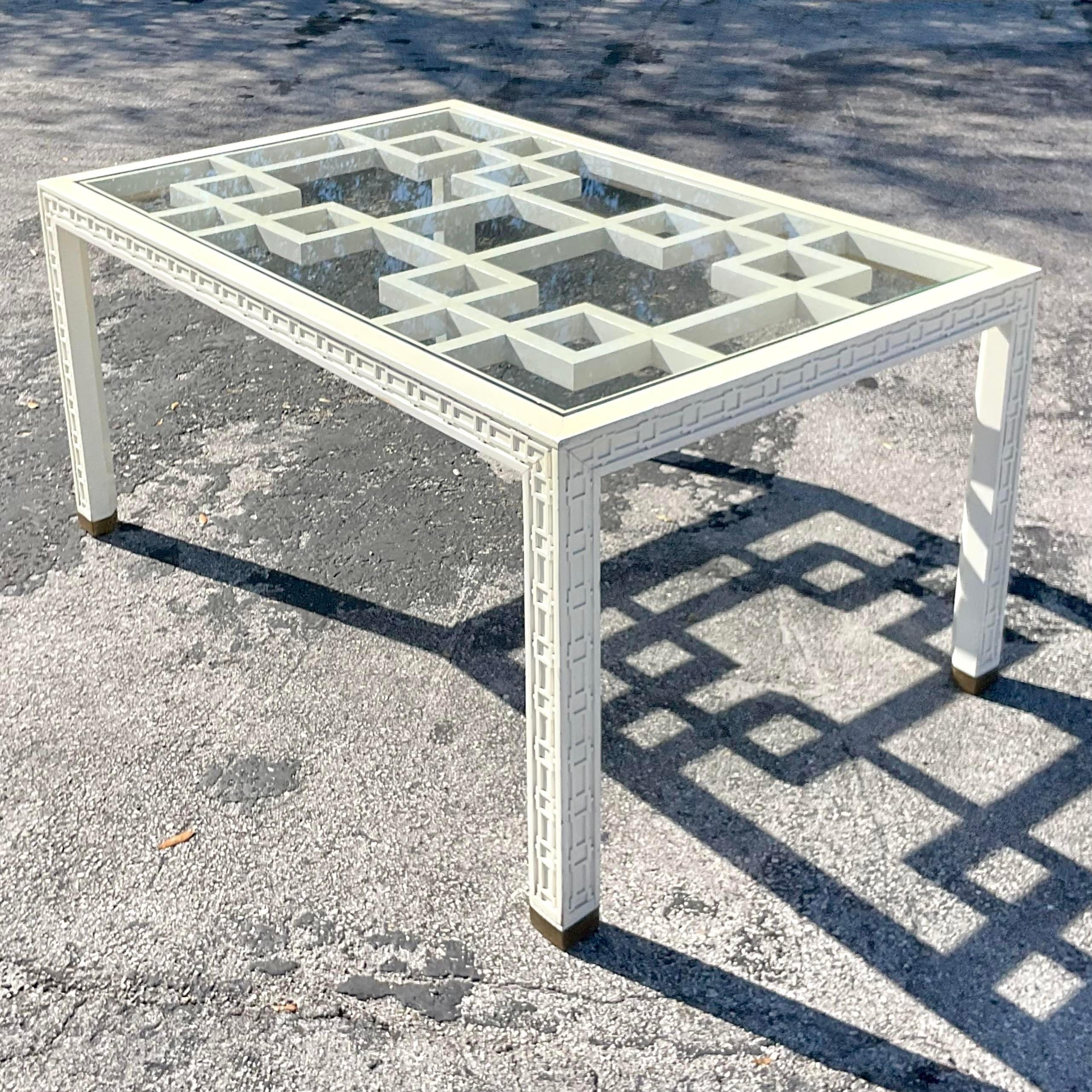 A fabulous vintage Regency dining table. A gorgeous Fretwork design with a massive inset fretwork panel below inset glass. A beautiful trim of fretwork along the edge. Acquired from a Palm Beach estate.
