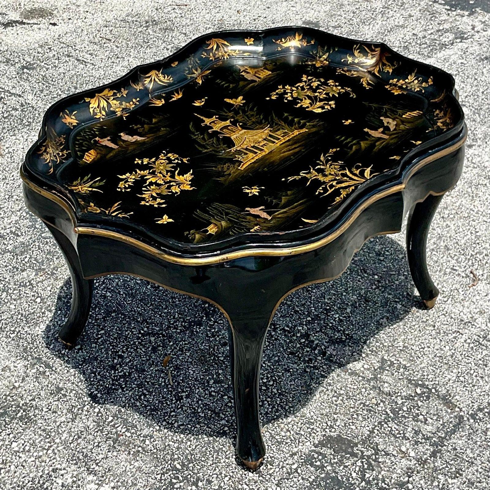 A fabulous vintage Regency coffee tray table. A stunning Paper Mache style with a black lacquered finish and gilt touches. Acquired from a Palm Beach estate.
