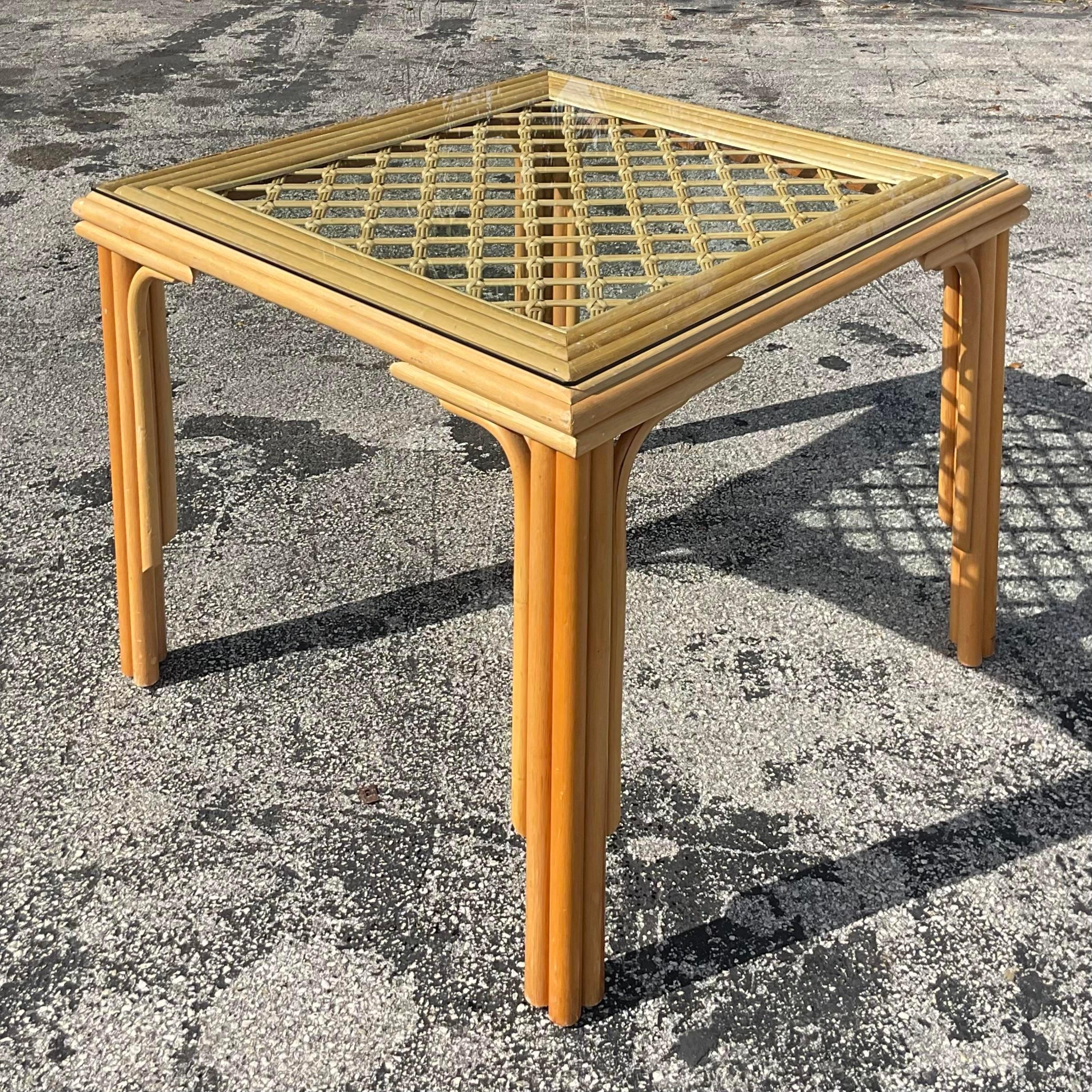 A gorgeous vintage game table made out of rattan and bamboo with a glass top. Acquired at a Palm Beach Estate. 
