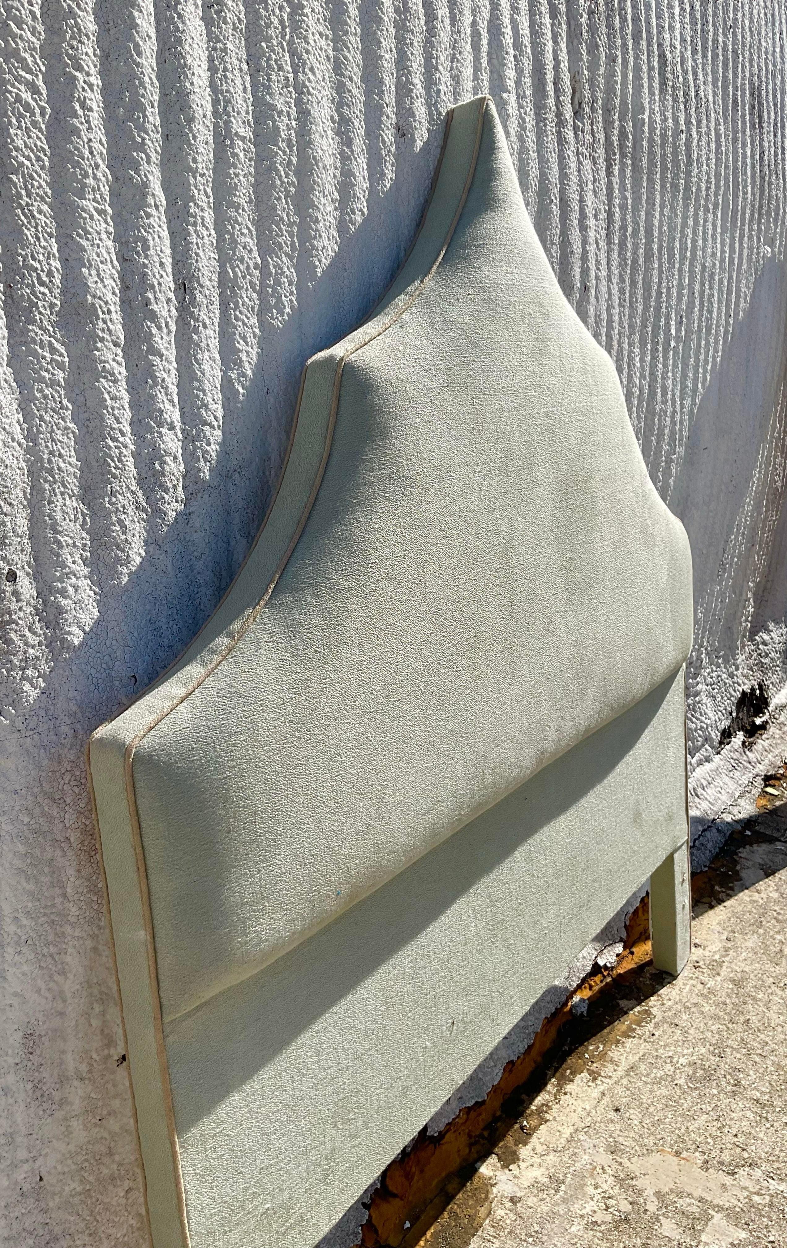 A lovely and unique vintage headboard that has been upholstered. The shape is truly one-of-a-kind. It will make your bedroom so chic. Acquired at a Palm Beach estate.