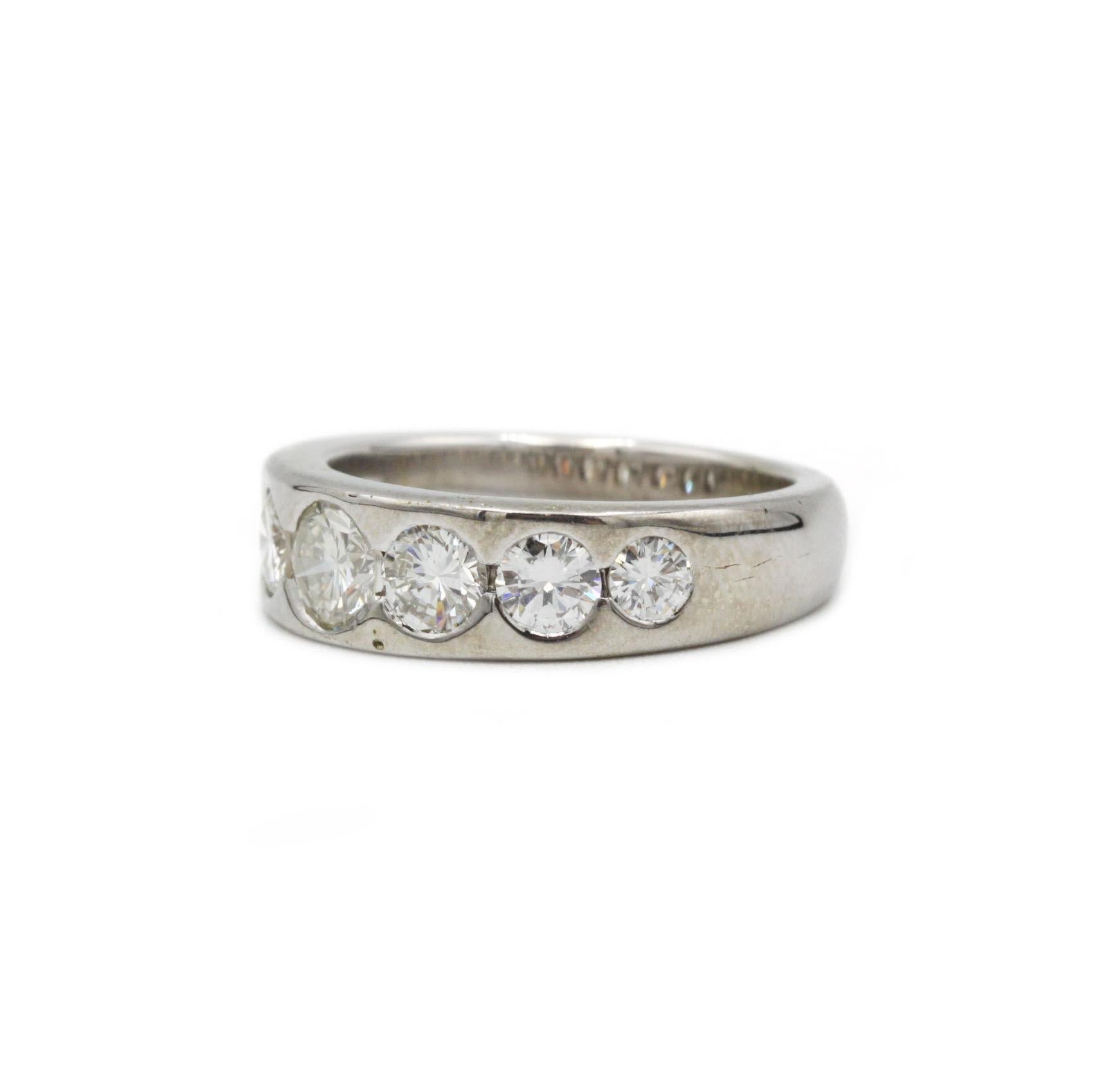 This striking half-eternity band embodies the confident geometry and understated luxury of mid-century design. Fashioned from 18-carat white gold, its broad, polished shank tapers gently toward the underside of the finger, offering both visual