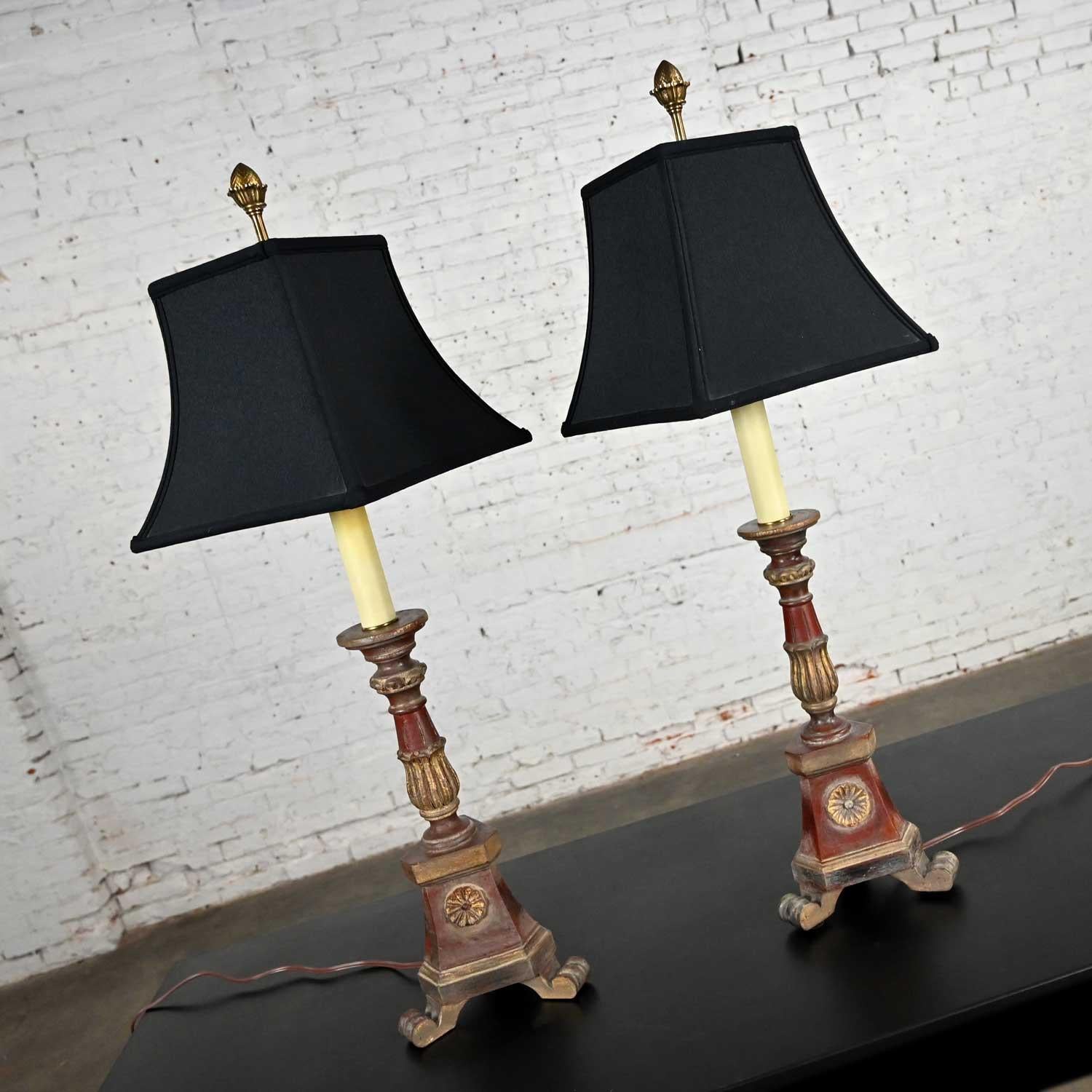 Wonderful pair of vintage Regency style pair of candlestick lamps comprised of carved wood bases with aged painted and gilded finish, linen-like gold lined squared bell-shaped shades, and a knob switch by Chapman. Beautiful condition, keeping in
