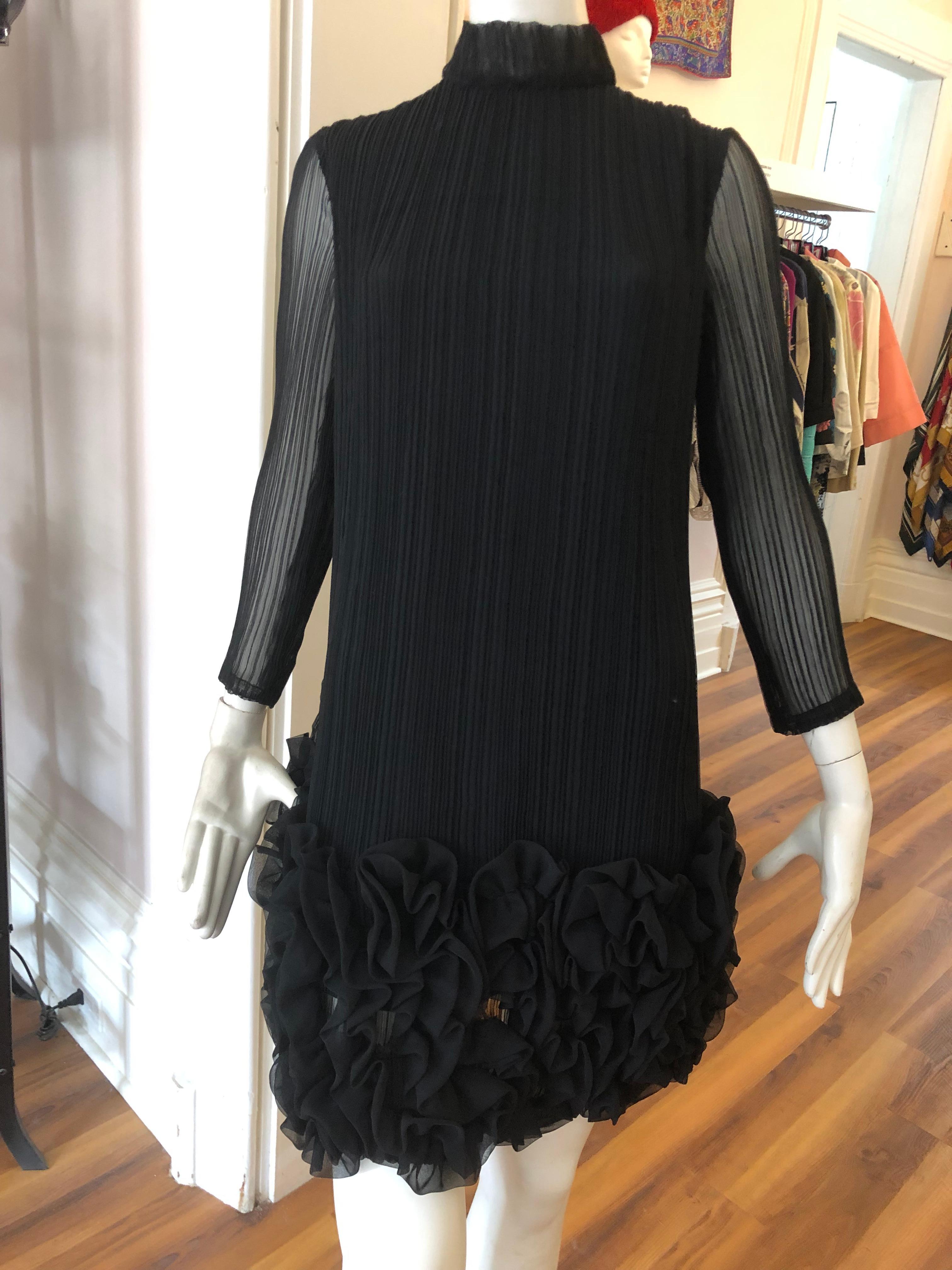 Wonderful permanent pleat dress, with elaborate ruching at bottom in a quasi floral pattern. The dress has a high neckline; see through sleeves and is lined. Closure is by way of a hidden centre back zipper. This is a truly magnificent piece in