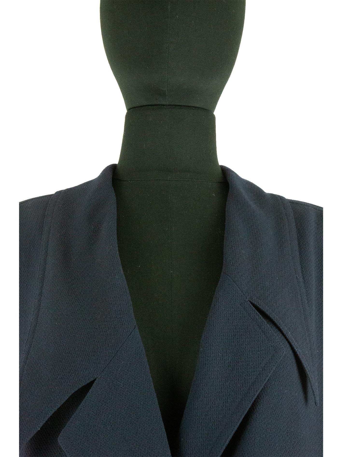 A late 1980s Largerfeld period Chanel jacket with an asymmetrical hemline. Crossing over from the right side over the left with the right side being the shorter of the two and joining together with two rows of two hook and eye fastenings and one