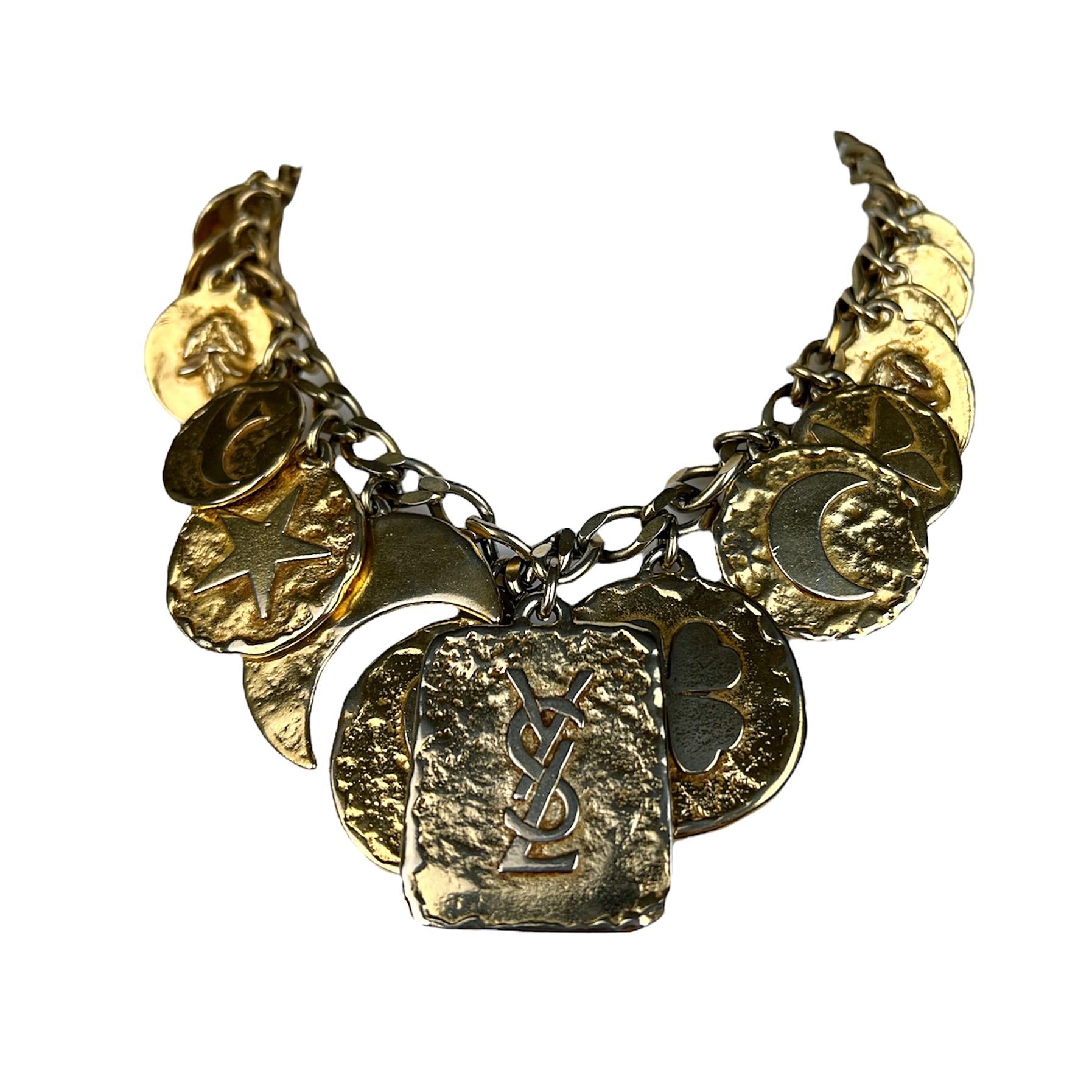 Gorgeous Yves Saint Laurent gold tone charms necklace from the 1980s. Each charm represents a symbol (with a meaning) that was dear to the heart of Yves Saint Laurent and that he has used all along his career on numerous occasion to adorn his