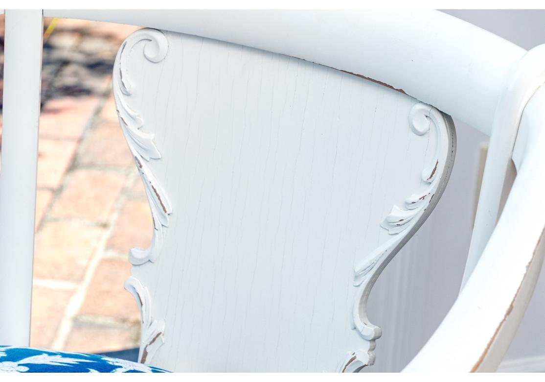 Sillón ancho del Imperio Americano tardío, bellamente tallado y pintado de blanco, con respaldo en forma de tablilla con volutas foliadas talladas en relieve.  Los brazos inclinados con bustos femeninos alados tallados y hojas sobre patas delanteras