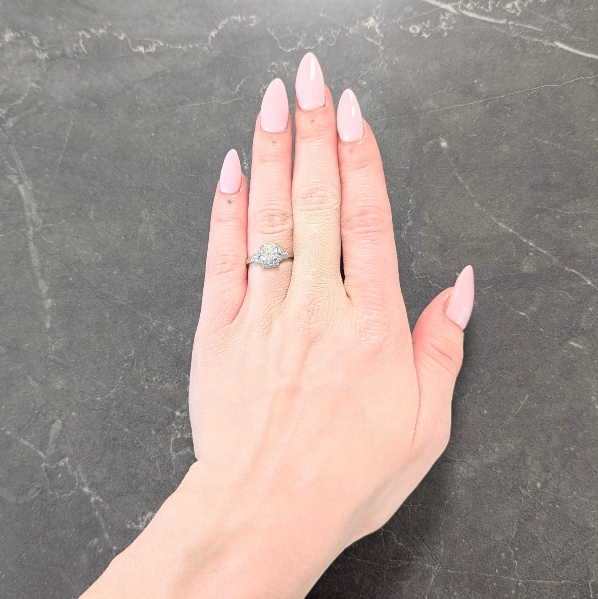 Centering a transitional cut diamond weighing approximately 1.02 carats - H color with SI1 clarity
Set with tri-split prongs in a square form head with clustered surround
Flanked by split shoulders - bead set with single cut diamonds
Weighing