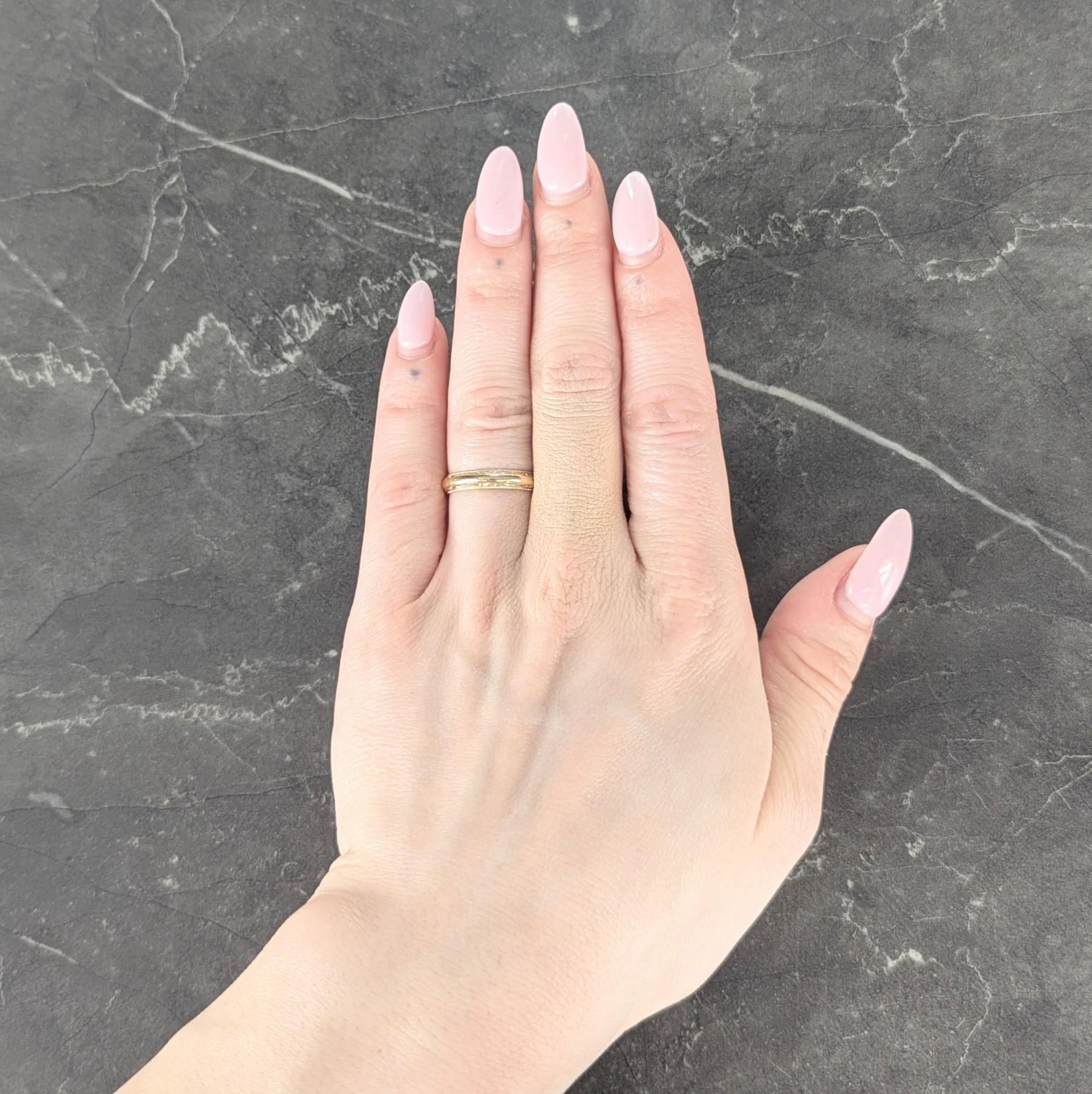 Conçu comme un anneau légèrement arrondi
Avec un bord rainuré à facettes
Accentué par des bords en milgrain
Avec une finition polie
Estampillé pour l'or 14 carats
Avec marque partielle de l'auteur
Circa : 1935
Taille de la bague : 6 1/2 et assez