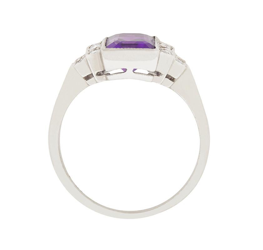 This stunning ring features the birthstone of February in all it's glory! The vibrant, deep purple Amethyst, weighs 1.85 carat and is in a rub over setting made of 18 carat white gold. Grain set diamonds sparkle in the stepped shoulders. The total