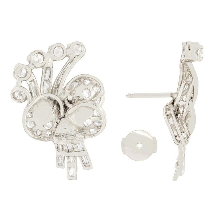 These show stopping earrings date back to the 1930s. Hand crafted from platinum each earring takes the shape of a bunch of flowers. Across the petals of each earring sit sixteen grain set eight cut diamonds, taking the form of the stalks are