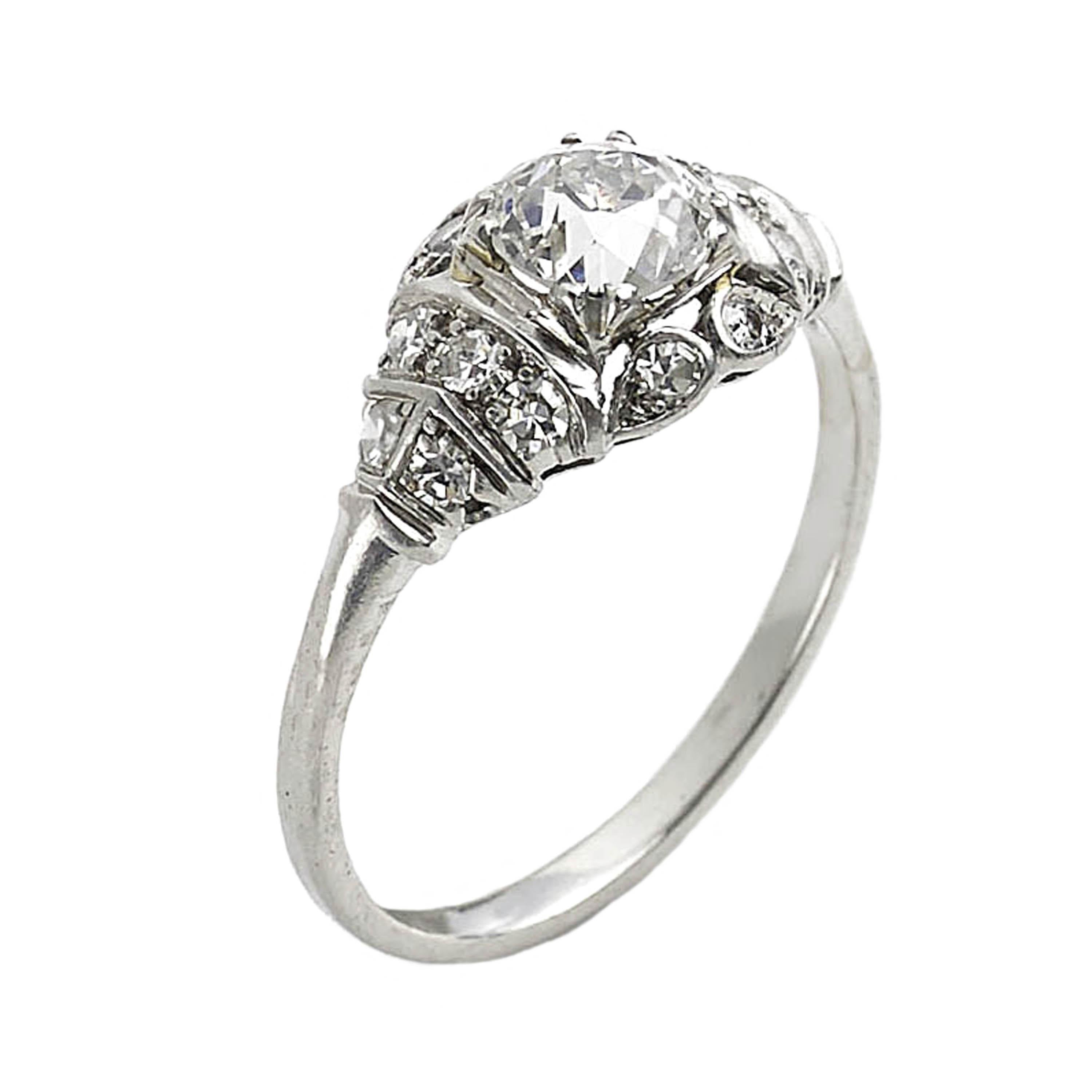 A late Art Deco diamond ring, set with a 0.85ct, H colour, SI1 clarity, Edwardian-cut diamond, in a four double claw setting, with an eight-cut diamond grain set, decorative surround and shoulders, mounted in platinum,  made in the USA, circa 1940.