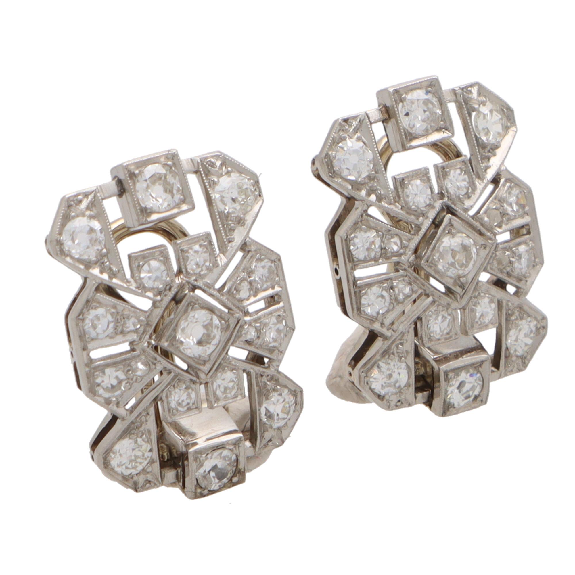 A beautiful pair of Late Art Deco diamond panel plaque earrings set in platinum and 18k white gold.

Each earring is designed as a pierced openwork panel grain-set with a mixture of old mine cut and transitional cut diamonds. The geometric motifs