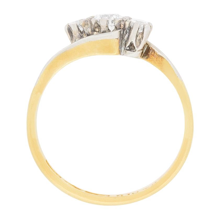Questo piccolo anello fatto a mano è un classico tre pietre con un intricato design a tortiglione. I diamanti, che sono tagli transitori, hanno un peso complessivo di 0,45 carati. Di colore F e di purezza VS, i diamanti brillano nelle loro collette