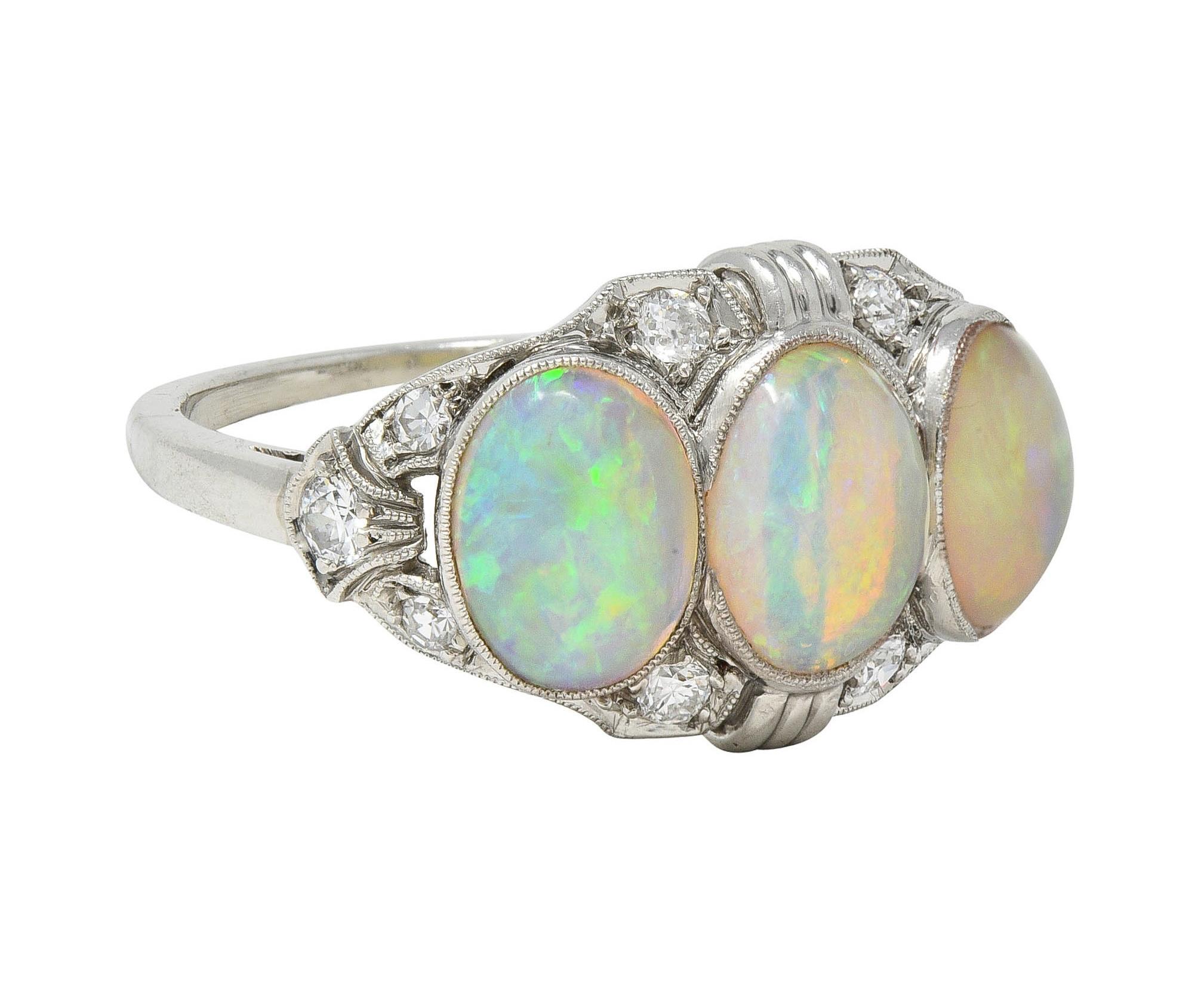 Featuring three oval-shaped opal cabochons bezel set east to west
Ranging in size from 5.0 x 7.0 mm to 6.0 x 8.0 mm
Translucent white body color with spectral play-of-color
Accented by single cut diamonds bead set throughout
Weighing approximately