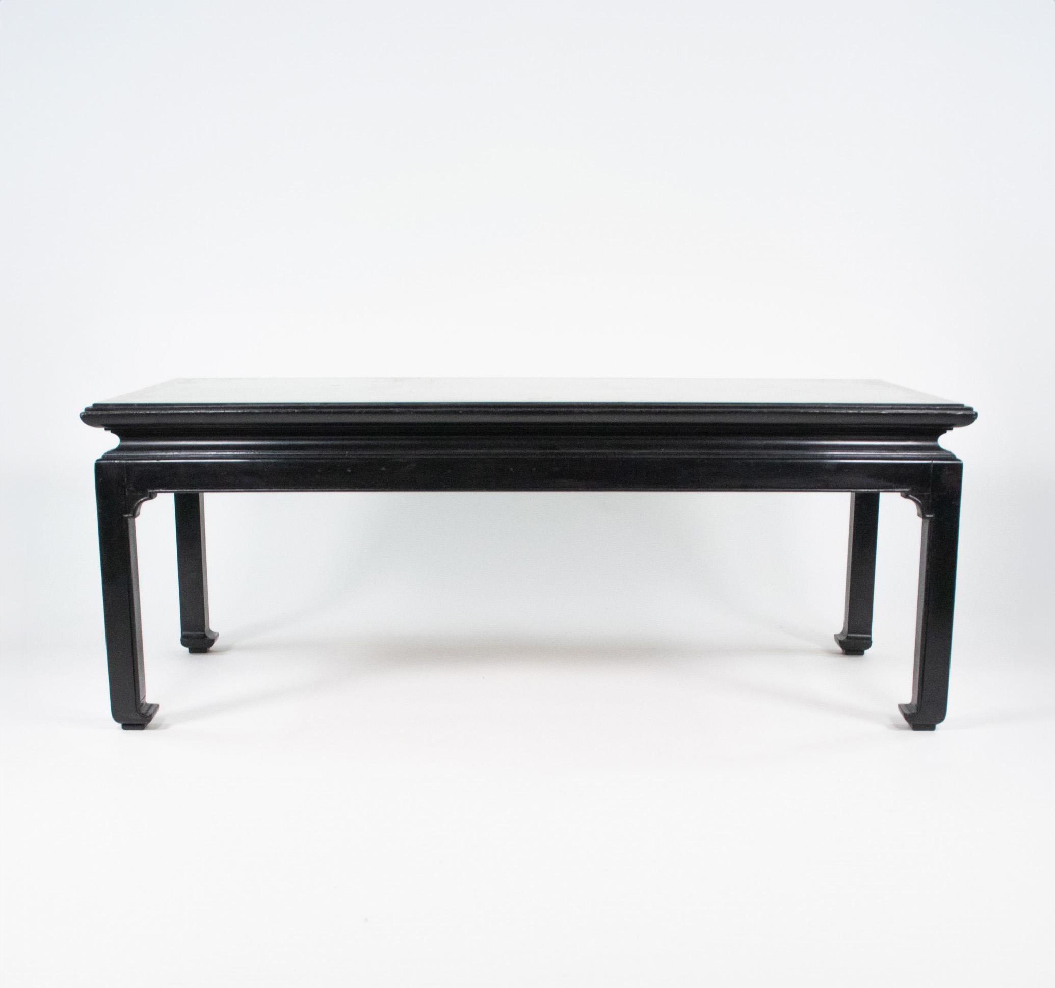 This exquisite late art deco low coffee table is attributed to Maison Jansen of Paris. The coffee table is made of ebonized wood with an inset glass top decorated with gold and silver leaf. The surface design resembles a mirror in a gold frame. Both