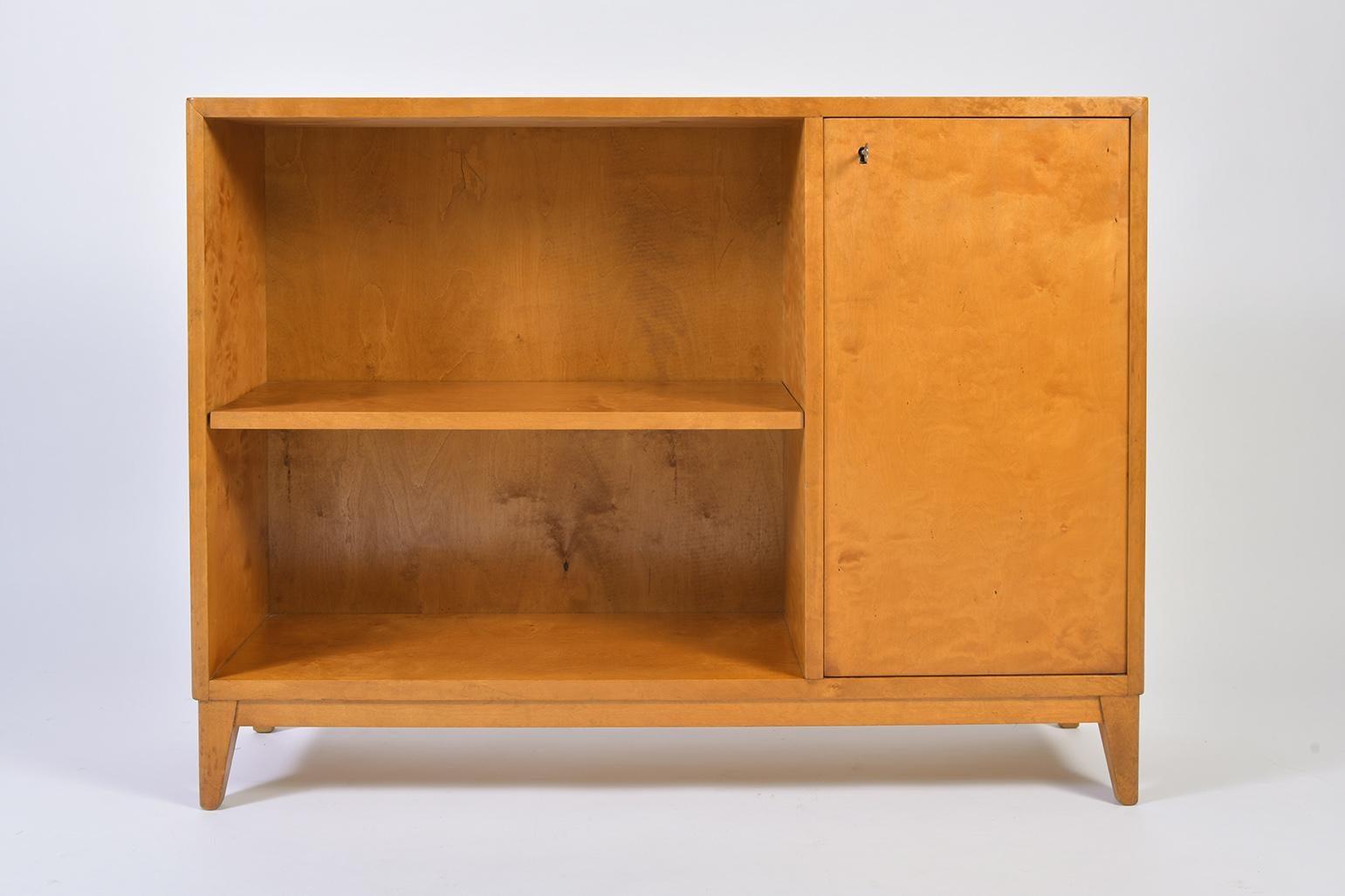 A birch cabinet, the left hand-side section with an adjustable shelf, the right-hand side cupboard revealing an adjustable shelf also, with its original key in working order.
Sweden, late 1940s.