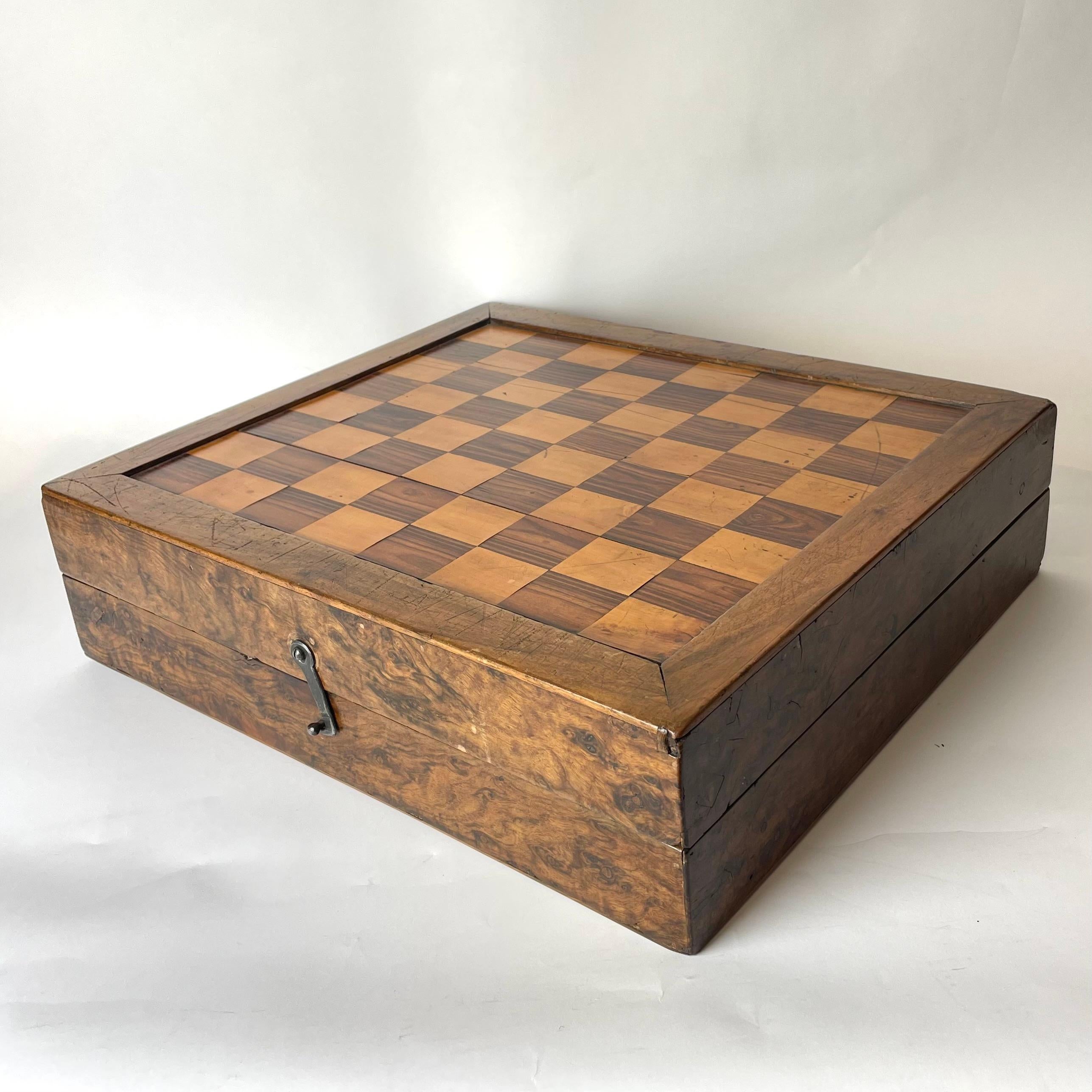 Une belle boîte de style baroque tardif utilisée pour les échecs, le backgammon et les pièces du jeu de Morris de Nine Men. Intérieur et extérieur richement décorés avec différents types de bois, notamment l'olivier, le noyer et le bouleau. Fin du