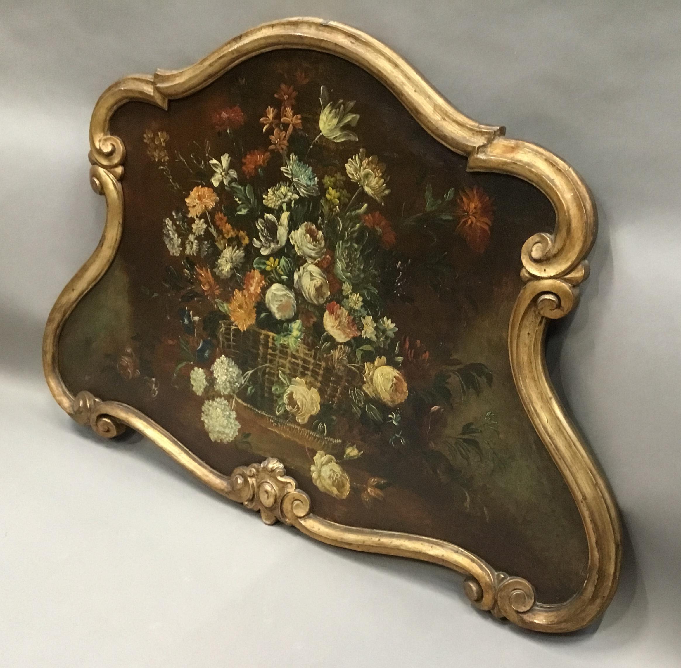 Late 18th century Dutch still life oil painting of unusual cartouche shape; the oil painting on canvas of an oval basket, overflowing with colorful flowers, housed in its original carved, scrollwork, giltwood frame. Very good original