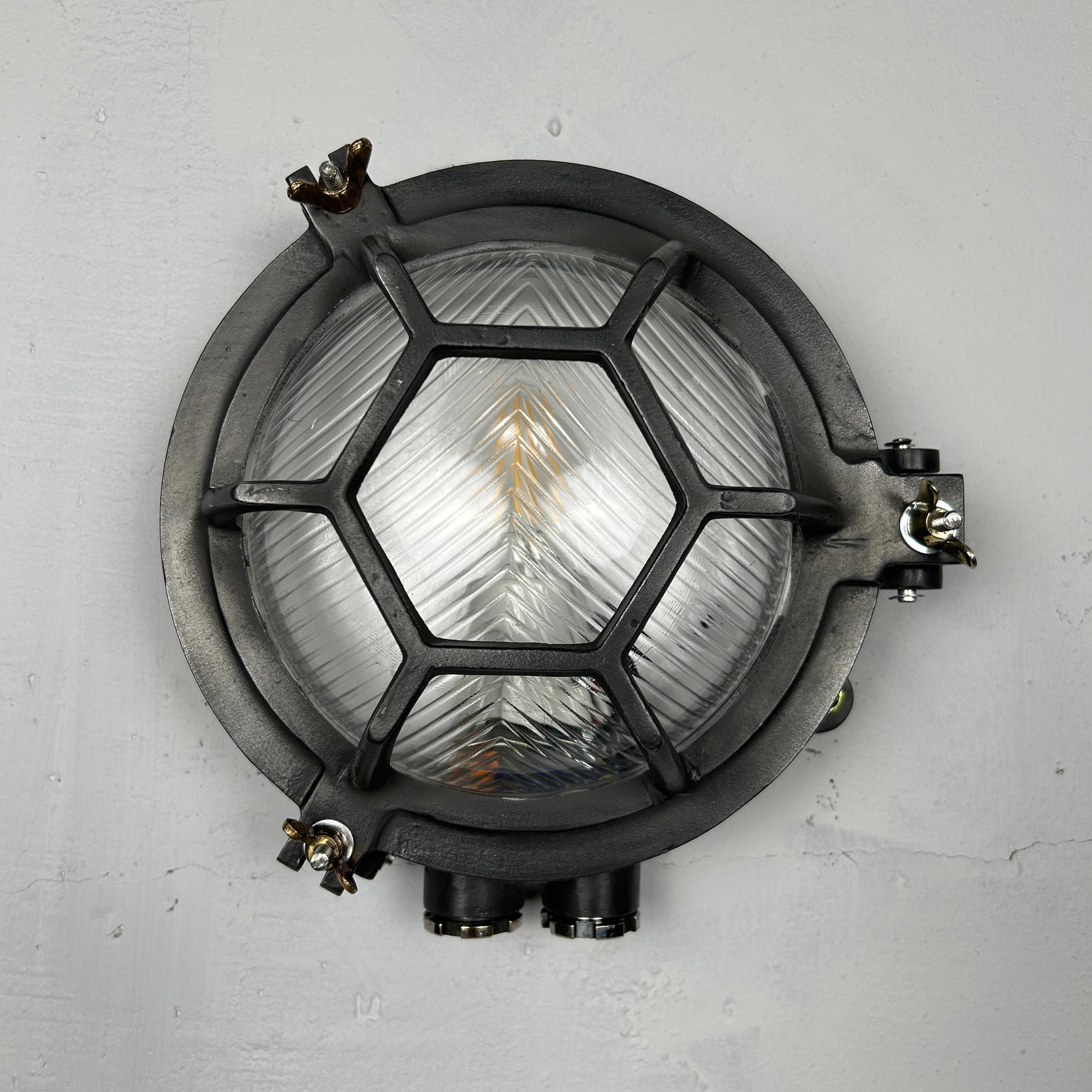 El aplique industrial de mamparo es un robusto aplique industrial redondo recuperado que incorpora una jaula hexagonal de aluminio fundido y un cristal biselado chevron que difumina maravillosamente la iluminación. Es la mejor iluminación