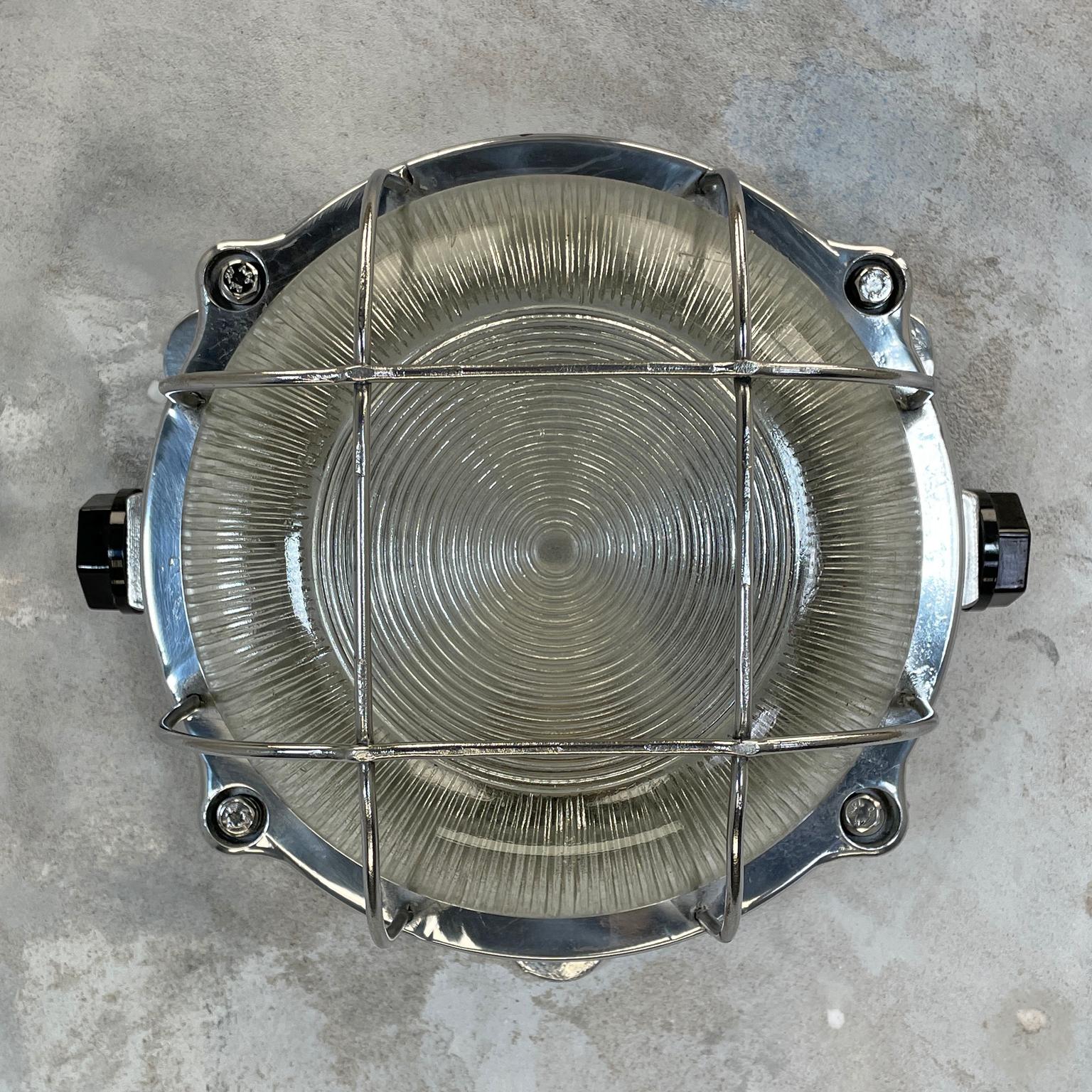 Vintage industrial aluminium outdoor circular bulkhead wall lighting with a chrome cage and prismatic / reeded glass to soften the illumination. Perfect robust and stylish outdoor light fixtures.

Specifications
Diameter: 25cm
Depth: