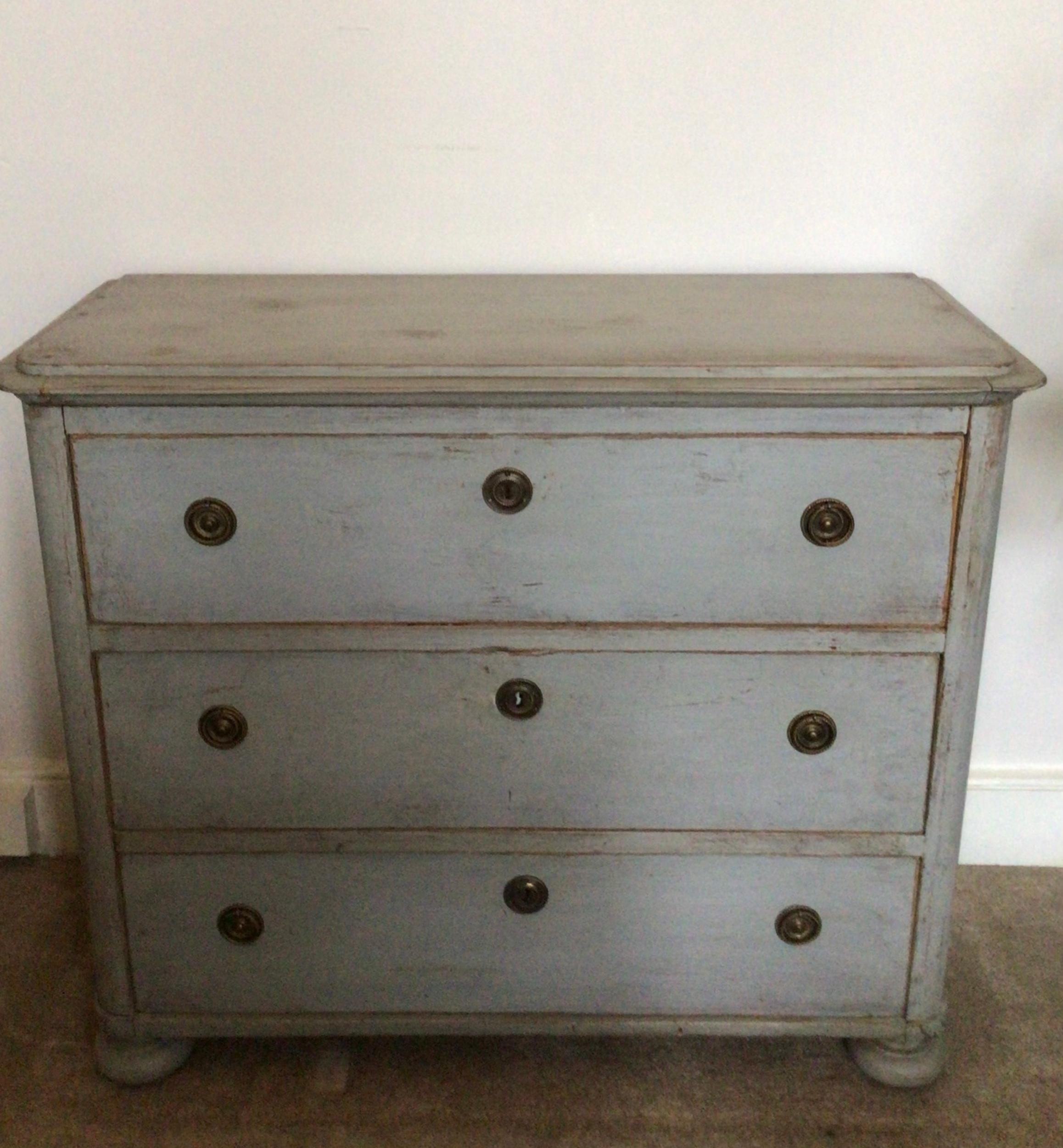 circa 1890s Swedish three drawer painted commode or chest of drawers which was most likely to have been adapted from a four drawer but now a more usable size as a bedside cabinet or for a smaller bedroom.
The paint is typically Scandinavian light